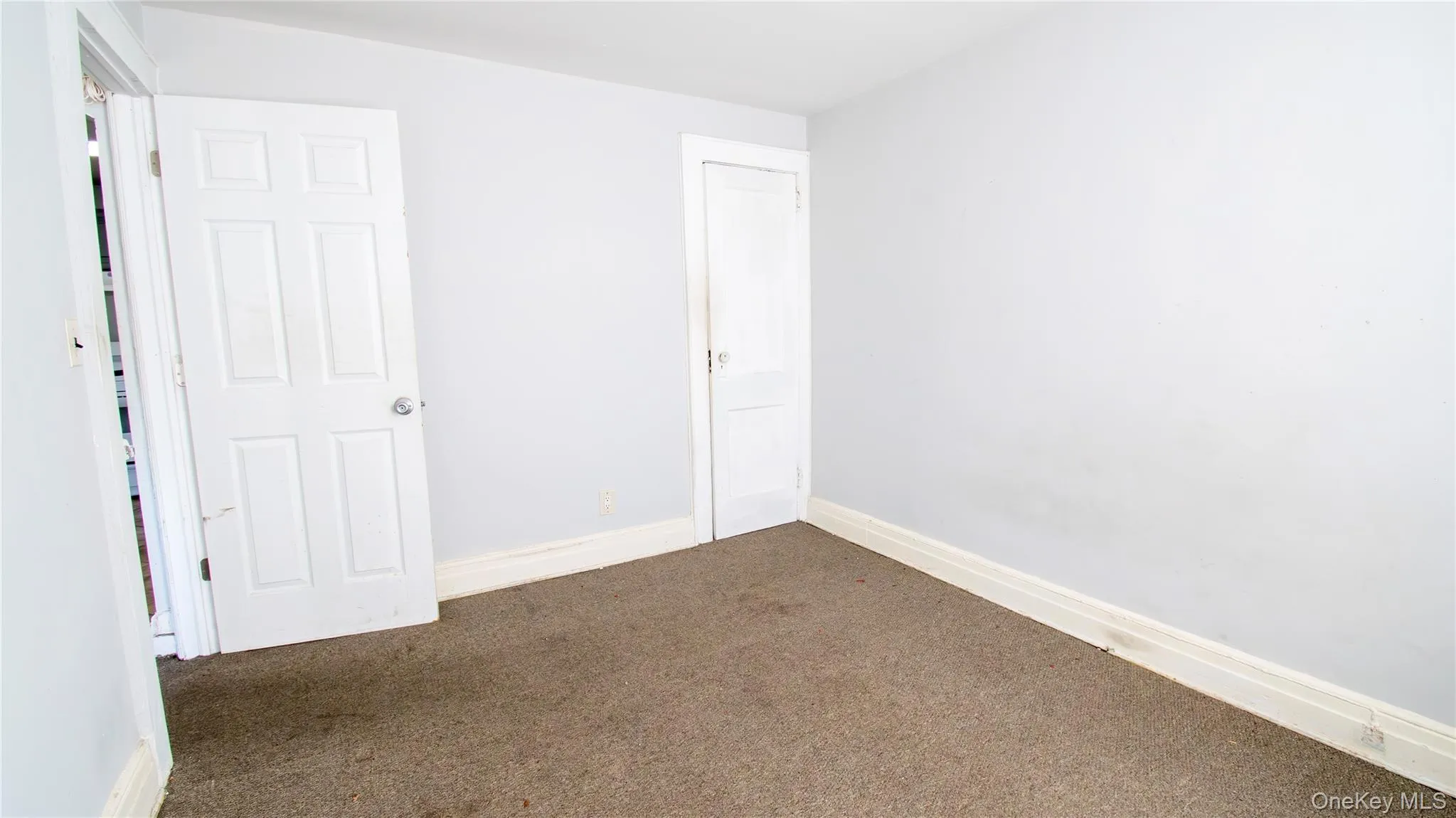 Unfurnished bedroom with carpet flooring and baseboards Unfurnished bedroom with carpet flooring and baseboards