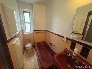 Bathroom with a garden tub, radiator heating unit, wainscoting, and tile walls Bathroom with a garden tub, radiator heating unit, wainscoting, and tile walls