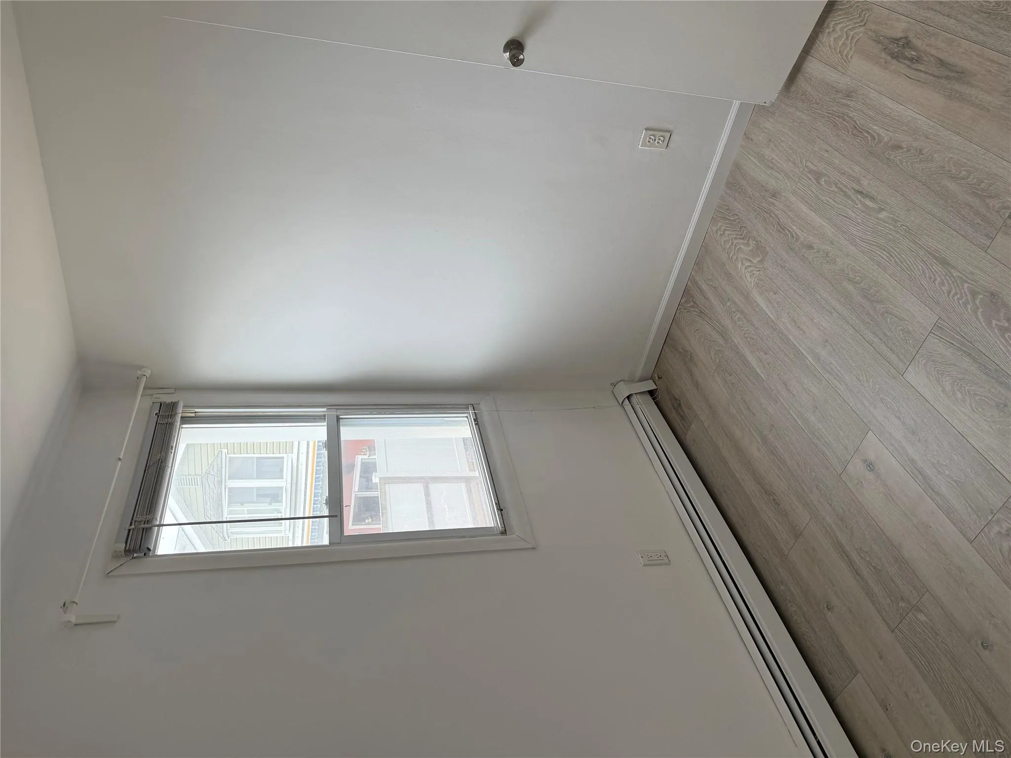 Spare room featuring a baseboard radiator and light wood-type flooring Spare room featuring a baseboard radiator and light wood-type flooring