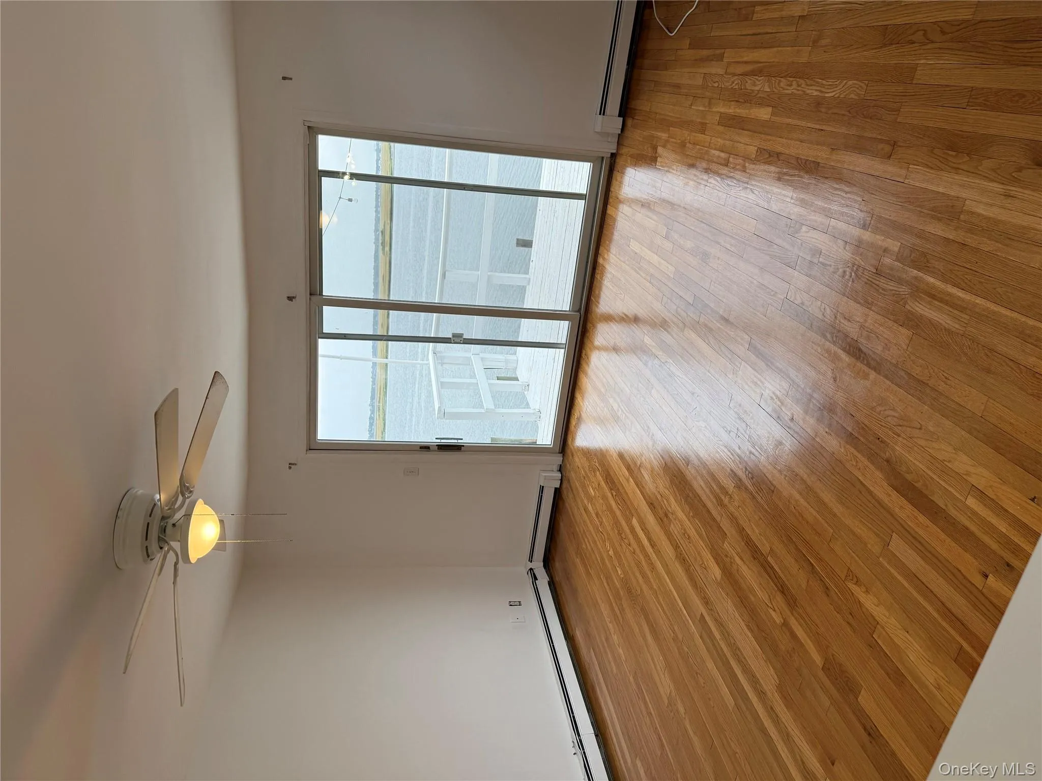 Spare room featuring light wood-type flooring, a water view, a baseboard heating unit, and ceiling fan Spare room featuring light wood-type flooring, a water view, a baseboard heating unit, and ceiling fan