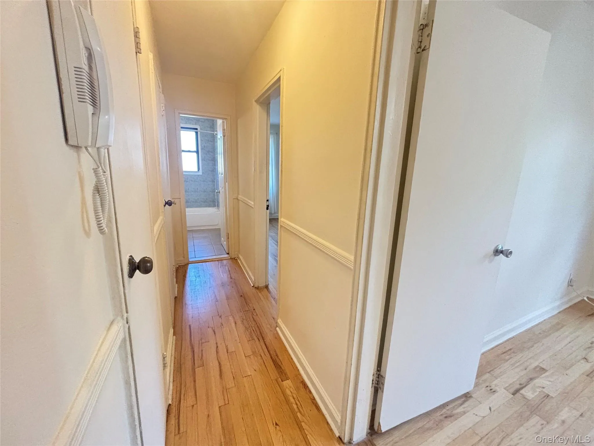Hallway with light wood-style flooring and baseboards Hallway with light wood-style flooring and baseboards