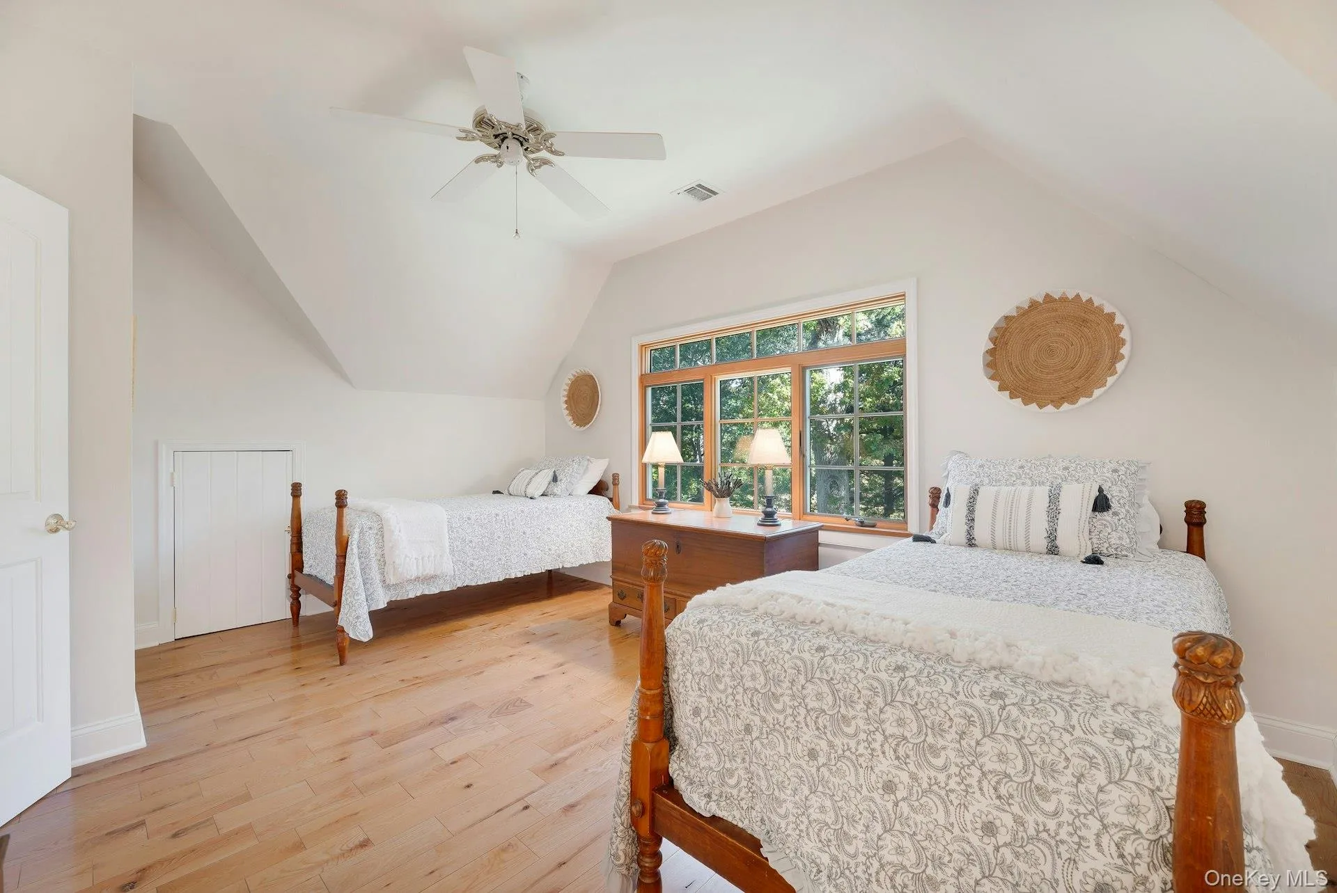 Bedroom with light wood finished floors, vaulted ceiling, and a ceiling fan Bedroom with light wood finished floors, vaulted ceiling, and a ceiling fan