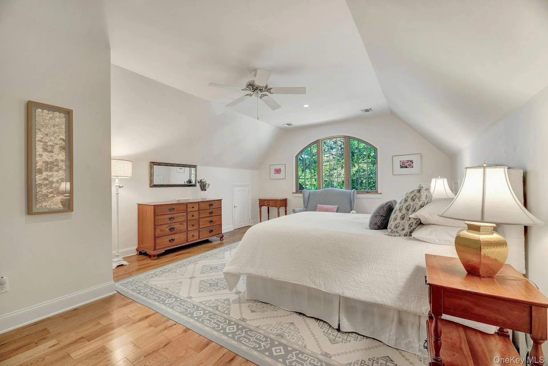 Bedroom featuring vaulted ceiling, light wood finished floors, and ceiling fan Bedroom featuring vaulted ceiling, light wood finished floors, and ceiling fan
