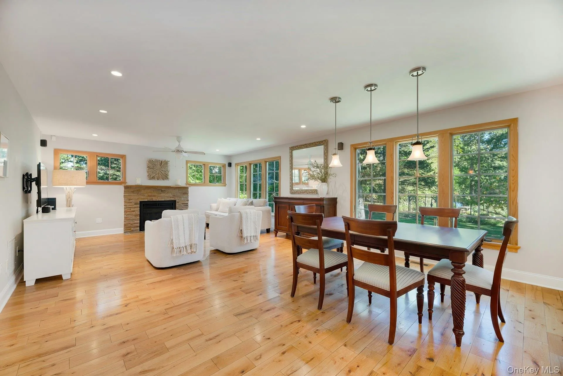 Dining space with a fireplace, light wood finished floors, recessed lighting, and ceiling fan Dining space with a fireplace, light wood finished floors, recessed lighting, and ceiling fan