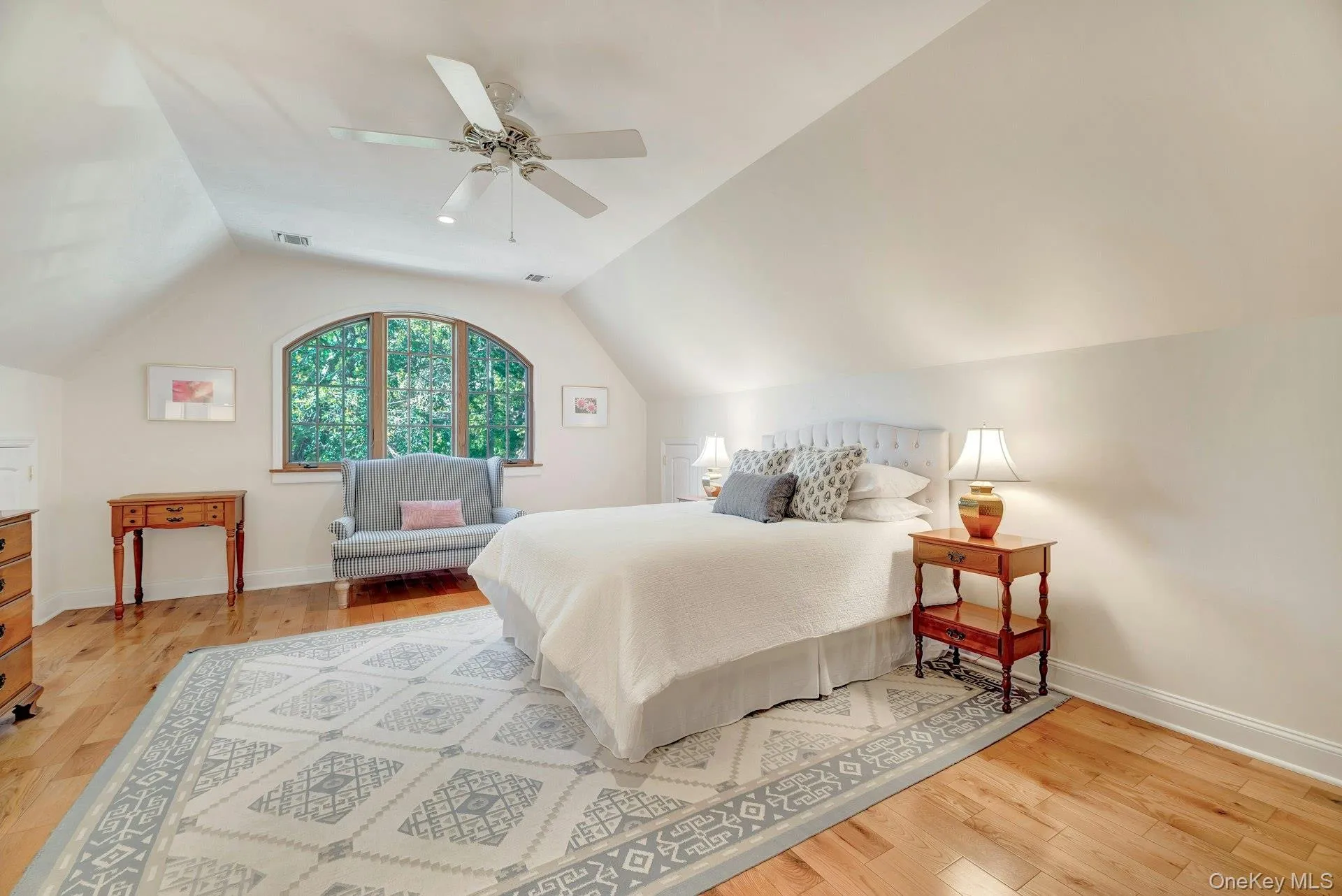 Bedroom featuring light wood finished floors, vaulted ceiling, and ceiling fan Bedroom featuring light wood finished floors, vaulted ceiling, and ceiling fan