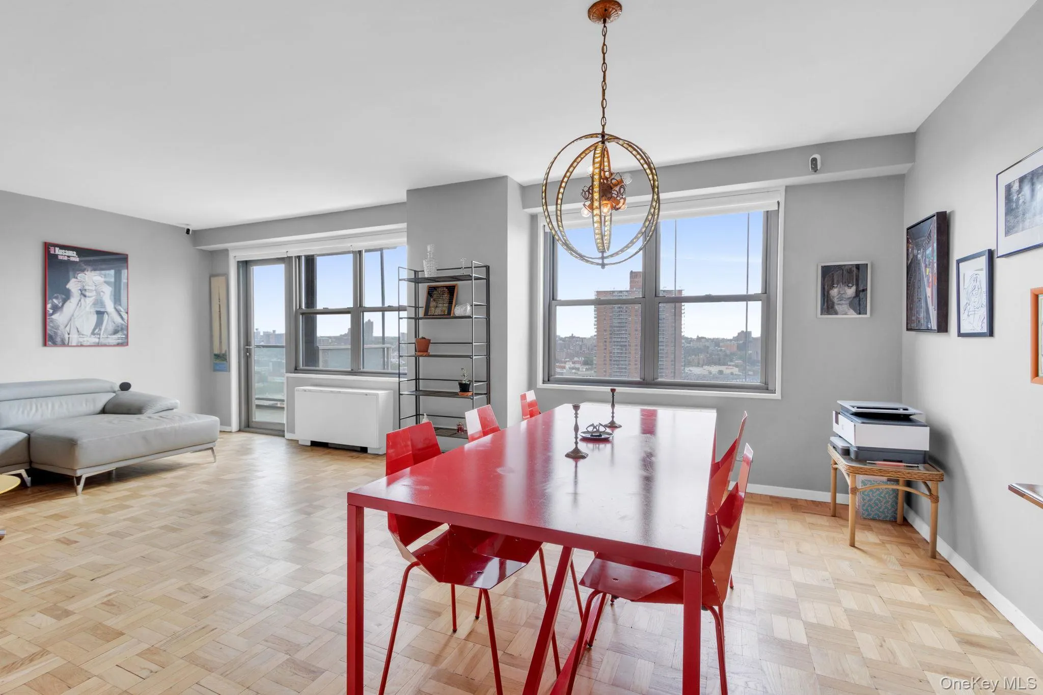 Dining space featuring plenty of natural light, radiator heating unit, a chandelier, and a city view Dining space featuring plenty of natural light, radiator heating unit, a chandelier, and a city view