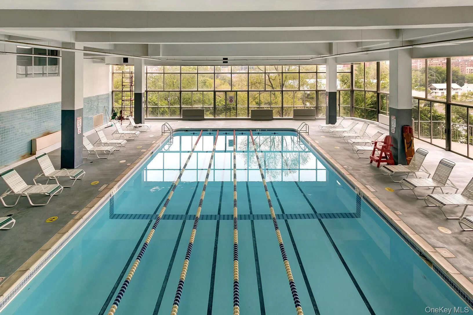 Indoor community pool featuring glass enclosure and a patio area Indoor community pool featuring glass enclosure and a patio area