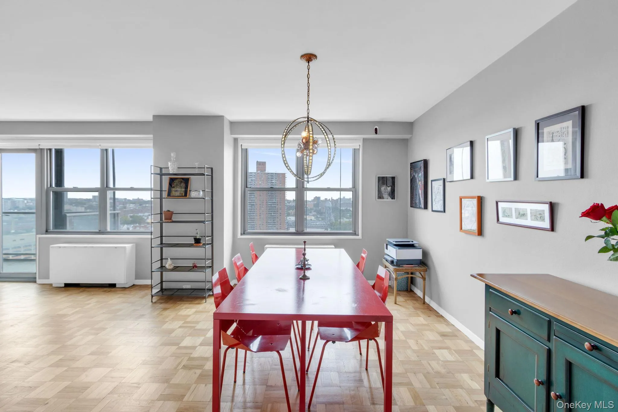 Dining room featuring radiator heating unit, plenty of natural light, a chandelier, and a view of city Dining room featuring radiator heating unit, plenty of natural light, a chandelier, and a view of city