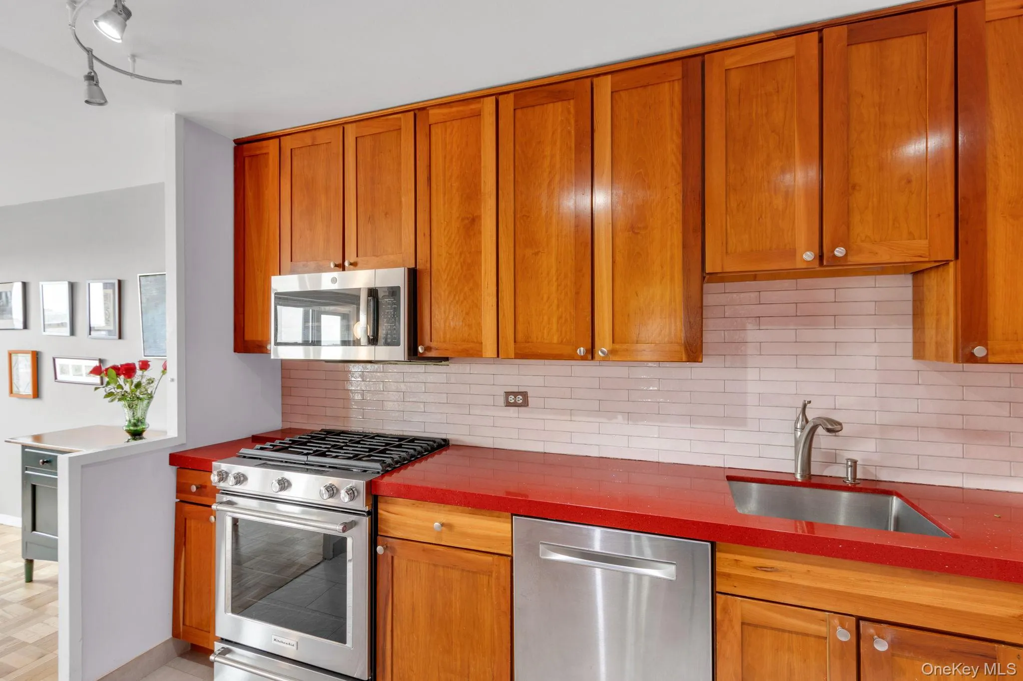 Kitchen featuring stainless steel appliances, brown cabinets, and backsplash Kitchen featuring stainless steel appliances, brown cabinets, and backsplash