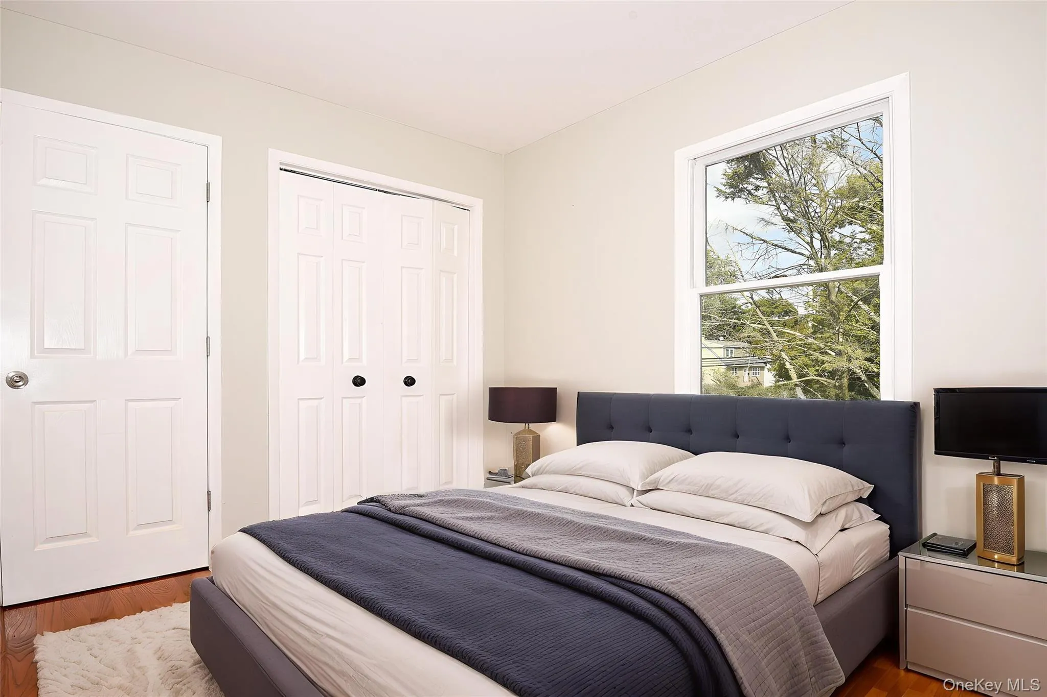 Bedroom featuring wood finished floors and a closet Bedroom featuring wood finished floors and a closet
