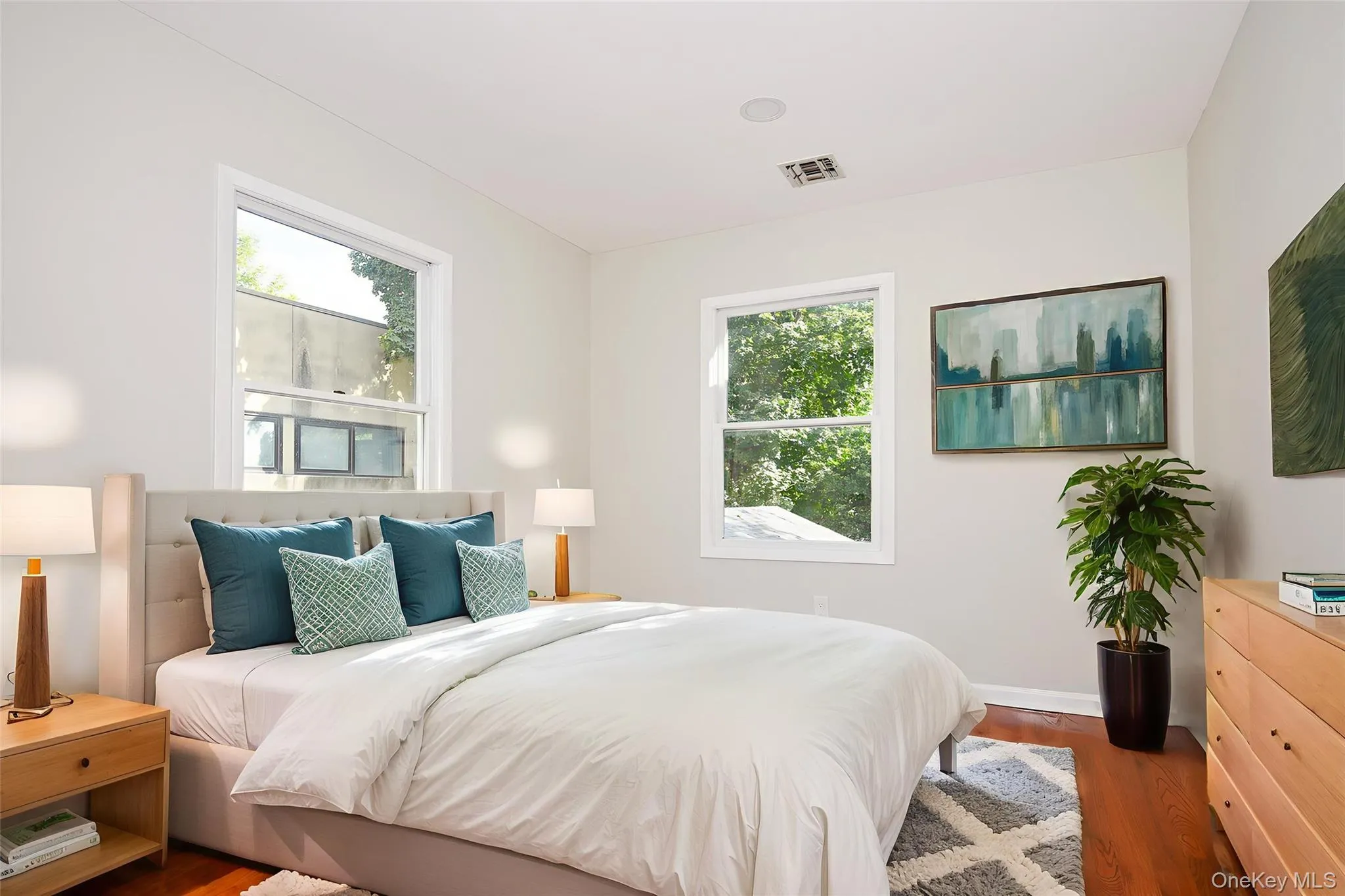 Bedroom featuring dark wood-type flooring and multiple windows Bedroom featuring dark wood-type flooring and multiple windows