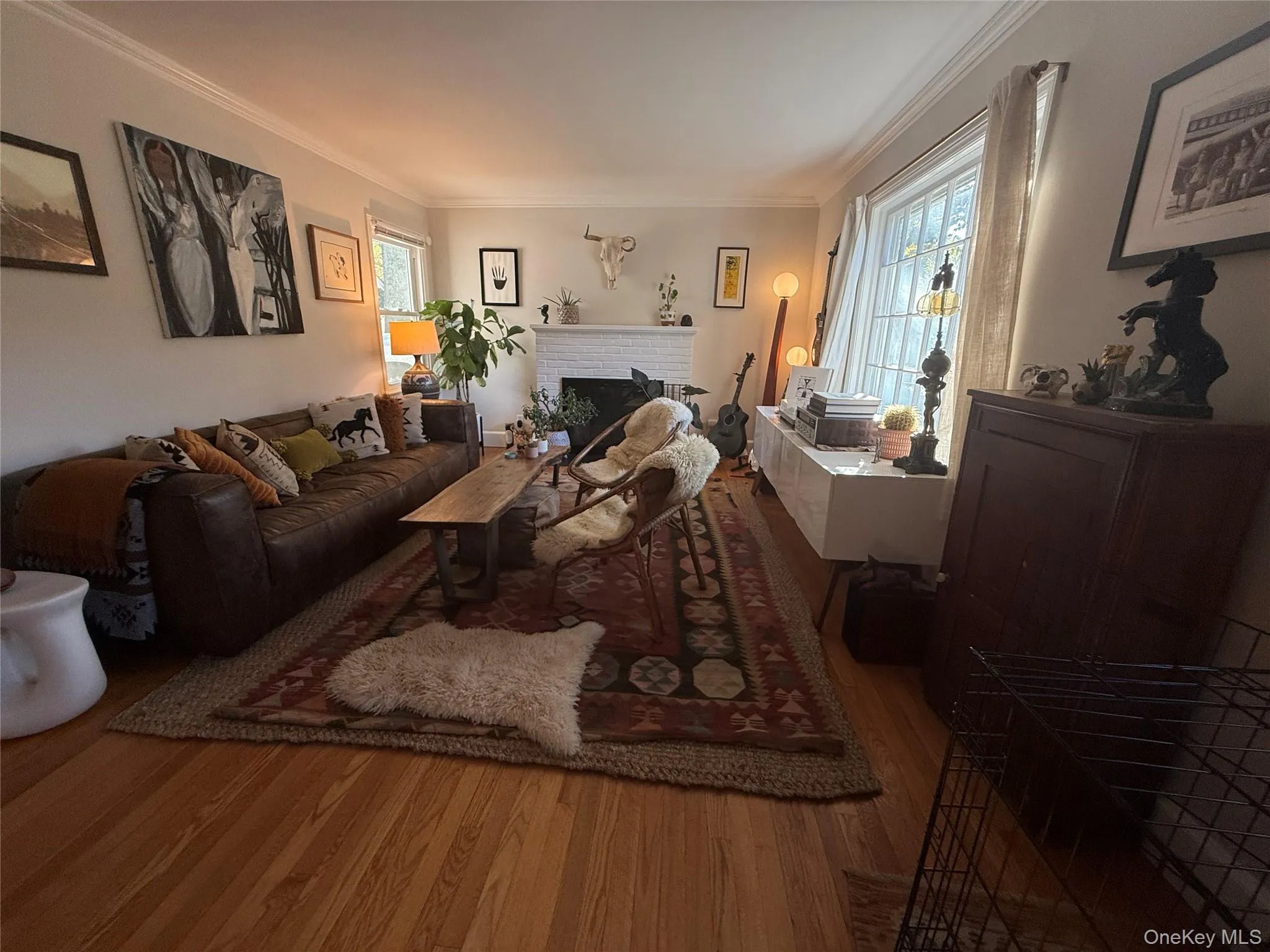 Living area featuring wood finished floors, and a fireplace Living area featuring wood finished floors, and a fireplace