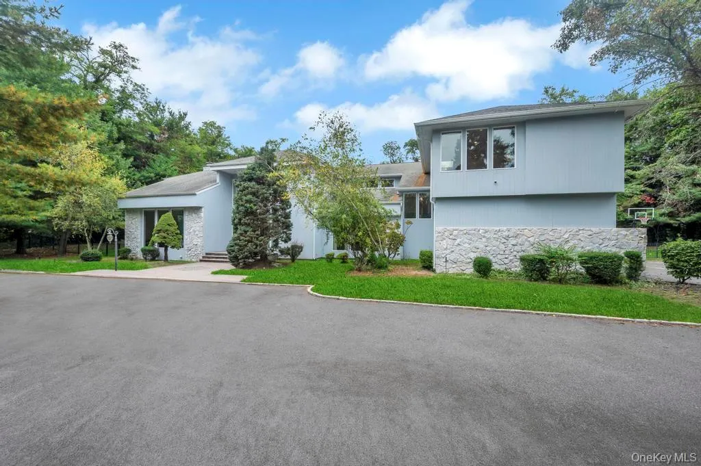 View of front facade featuring stone siding and a front yard View of front facade featuring stone siding and a front yard