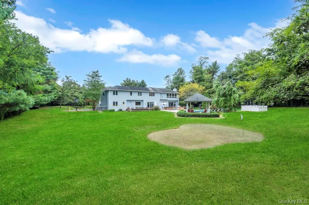 Rear view of house featuring a gazebo and view of scattered trees Rear view of house featuring a gazebo and view of scattered trees