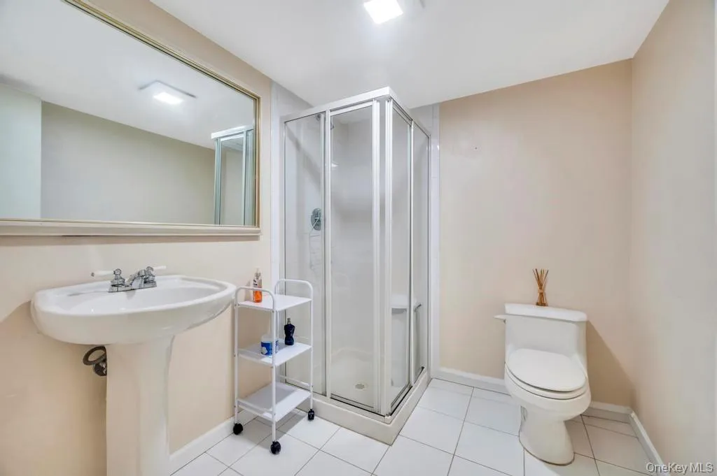 Bathroom with light tile patterned floors and a stall shower Bathroom with light tile patterned floors and a stall shower