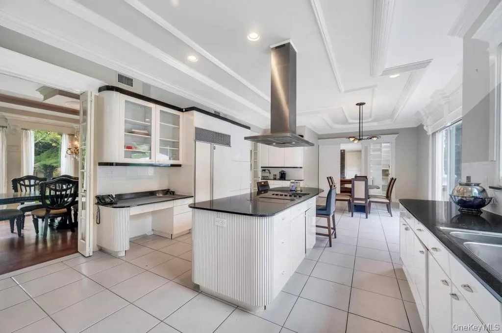 Kitchen featuring glass insert cabinets, plenty of natural light, white cabinetry, crown molding, and recessed lighting Kitchen featuring glass insert cabinets, plenty of natural light, white cabinetry, crown molding, and recessed lighting
