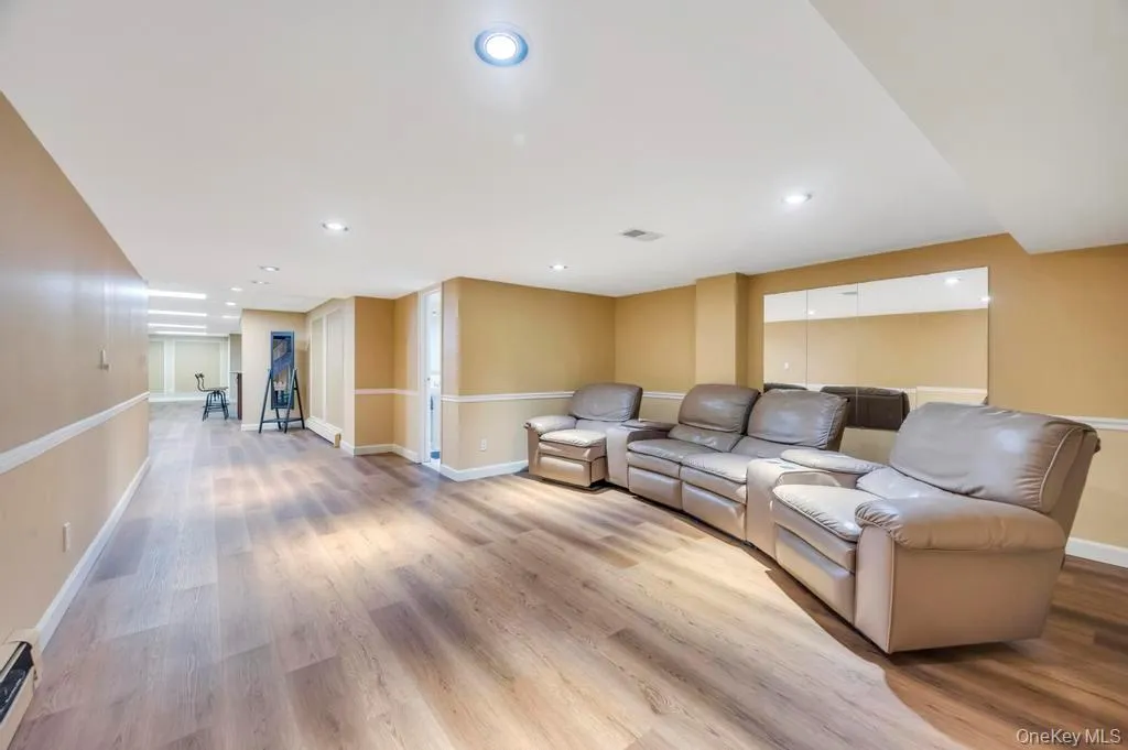 Living room with light wood-type flooring, recessed lighting, and baseboard heating Living room with light wood-type flooring, recessed lighting, and baseboard heating