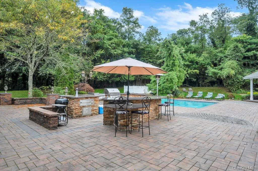 View of patio / terrace featuring an outdoor kitchen and an outdoor pool View of patio / terrace featuring an outdoor kitchen and an outdoor pool