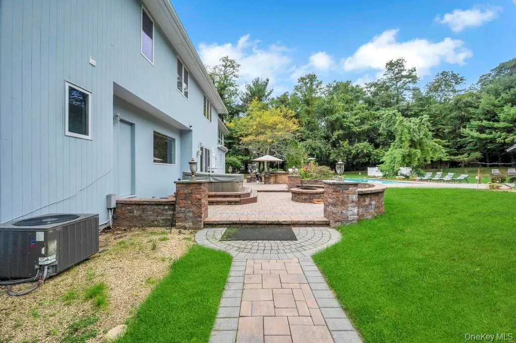 View of grassy yard with a patio area and view of scattered trees View of grassy yard with a patio area and view of scattered trees