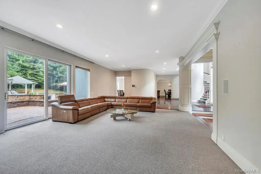 Carpeted living area featuring recessed lighting, stairs, ornamental molding, and arched walkways Carpeted living area featuring recessed lighting, stairs, ornamental molding, and arched walkways