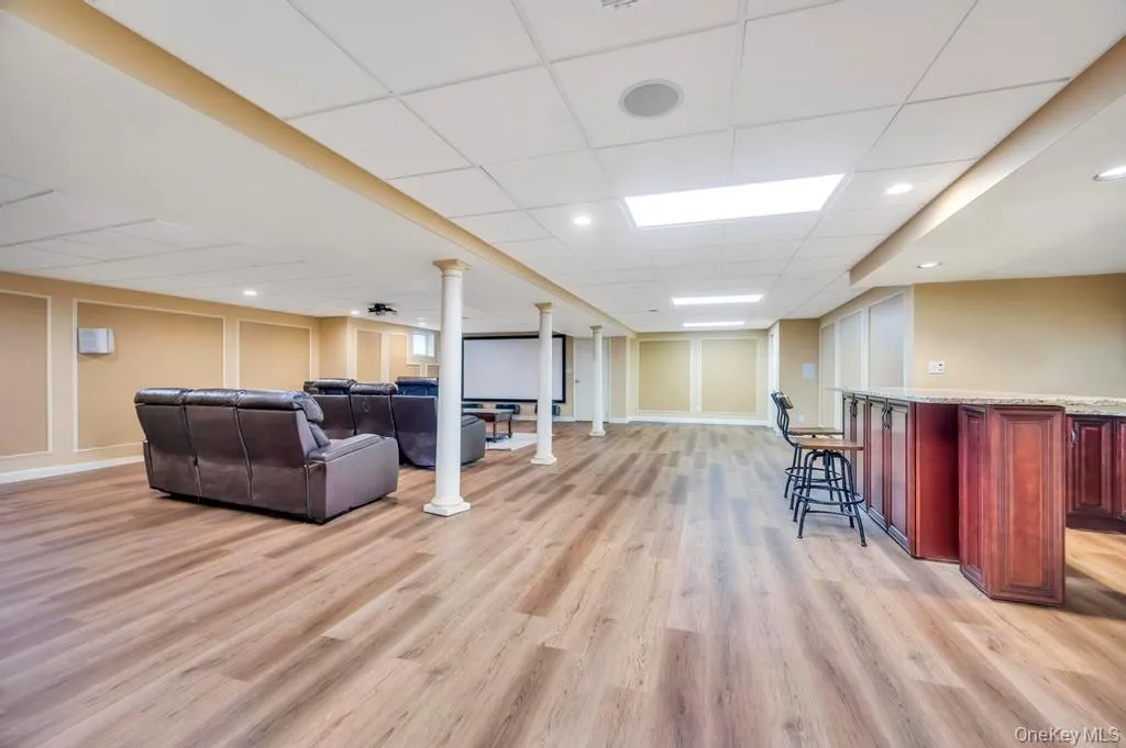 Living room with a paneled ceiling, light wood-style flooring, and recessed lighting Living room with a paneled ceiling, light wood-style flooring, and recessed lighting