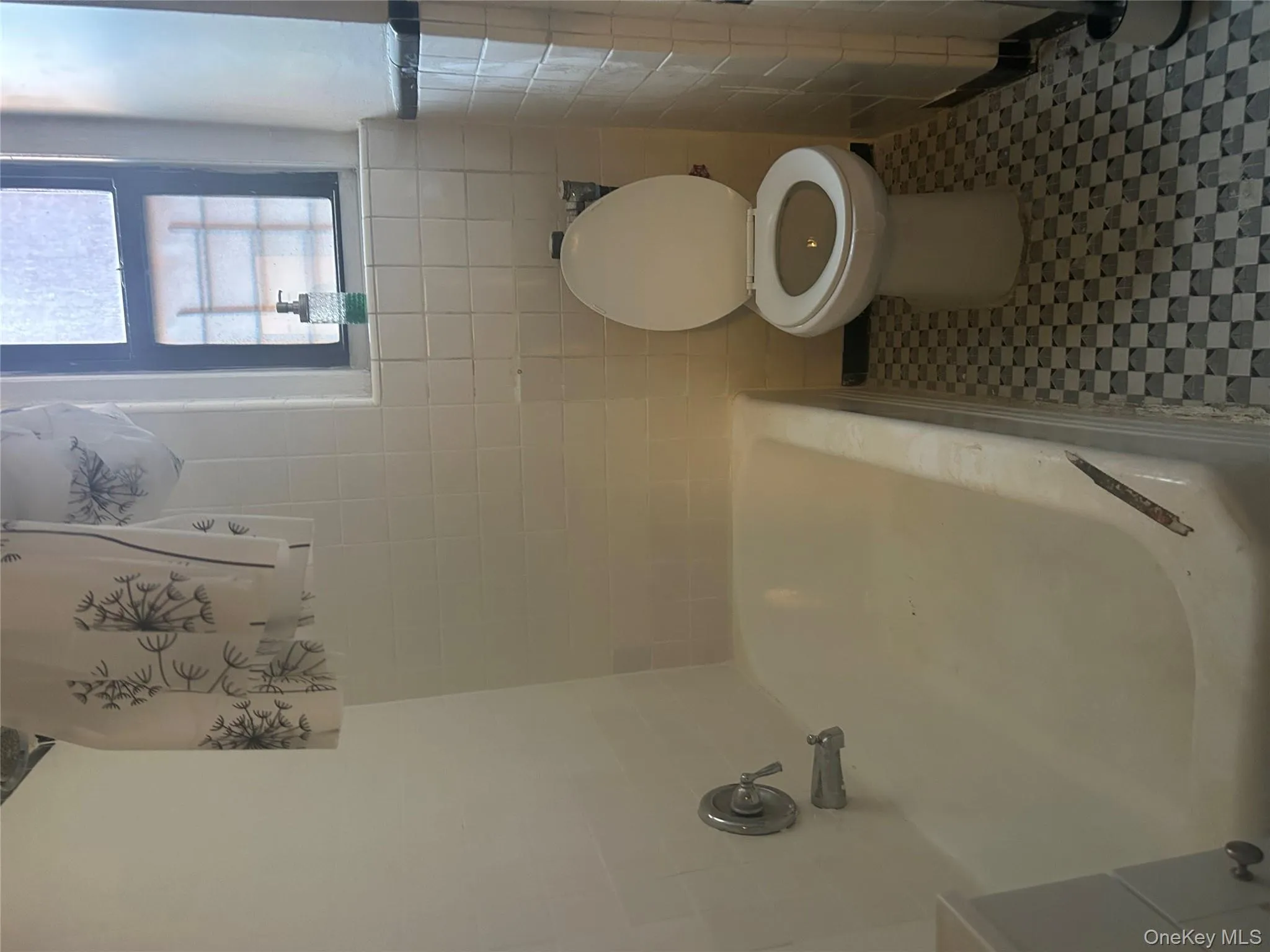 Full bathroom featuring tile walls and shower / bathtub combination Full bathroom featuring tile walls and shower / bathtub combination