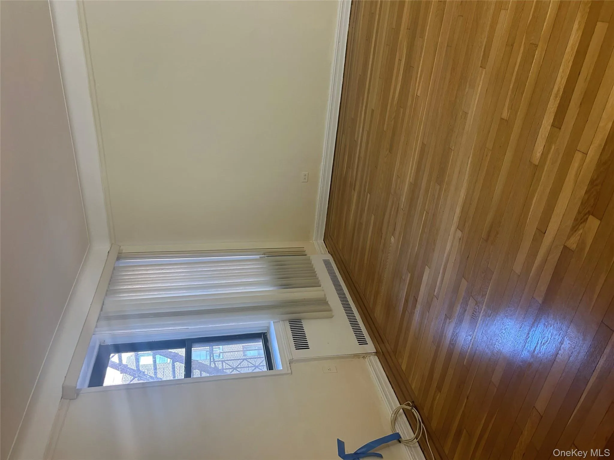 Empty room with hardwood / wood-style flooring and radiator Empty room with hardwood / wood-style flooring and radiator