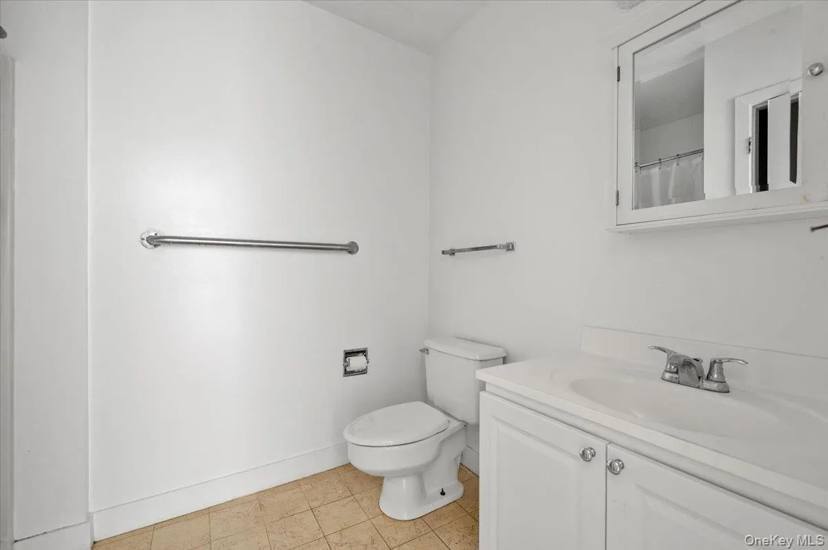 Bathroom featuring vanity, light tile patterned floors, and curtained shower Bathroom featuring vanity, light tile patterned floors, and curtained shower