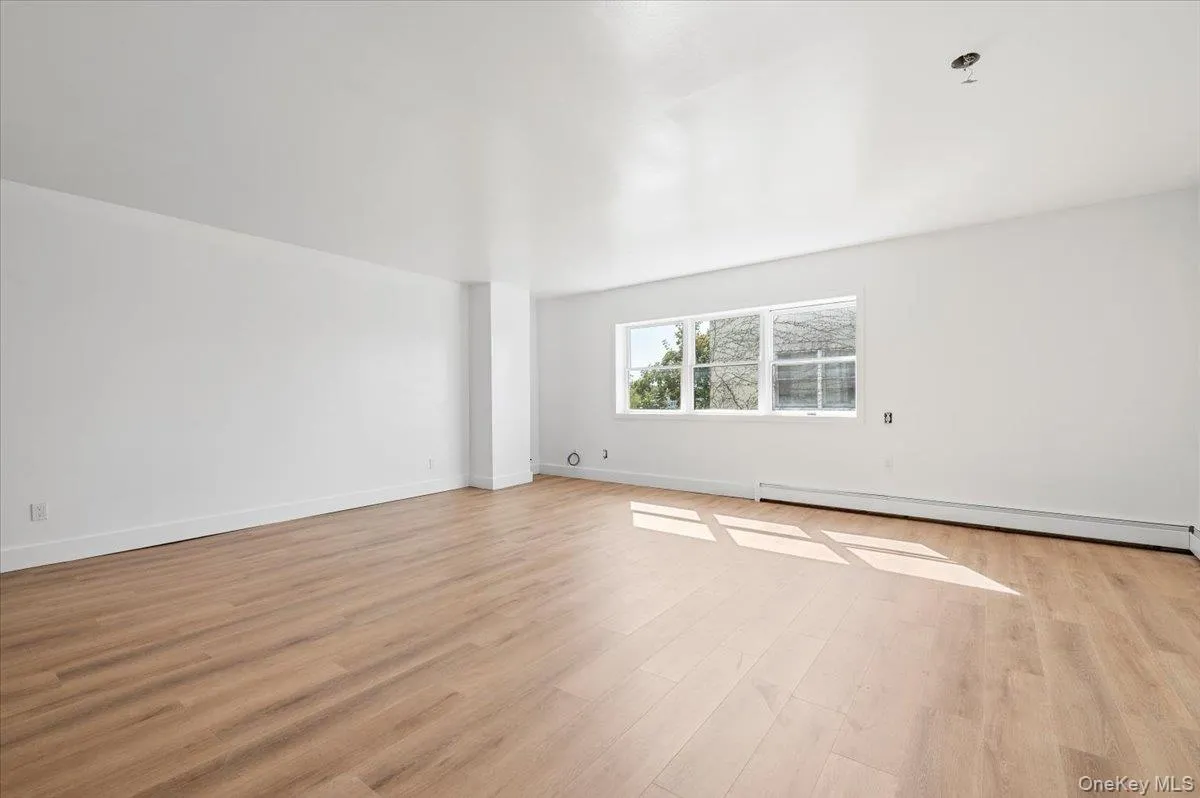 Spare room with a baseboard radiator and light wood-style floors Spare room with a baseboard radiator and light wood-style floors