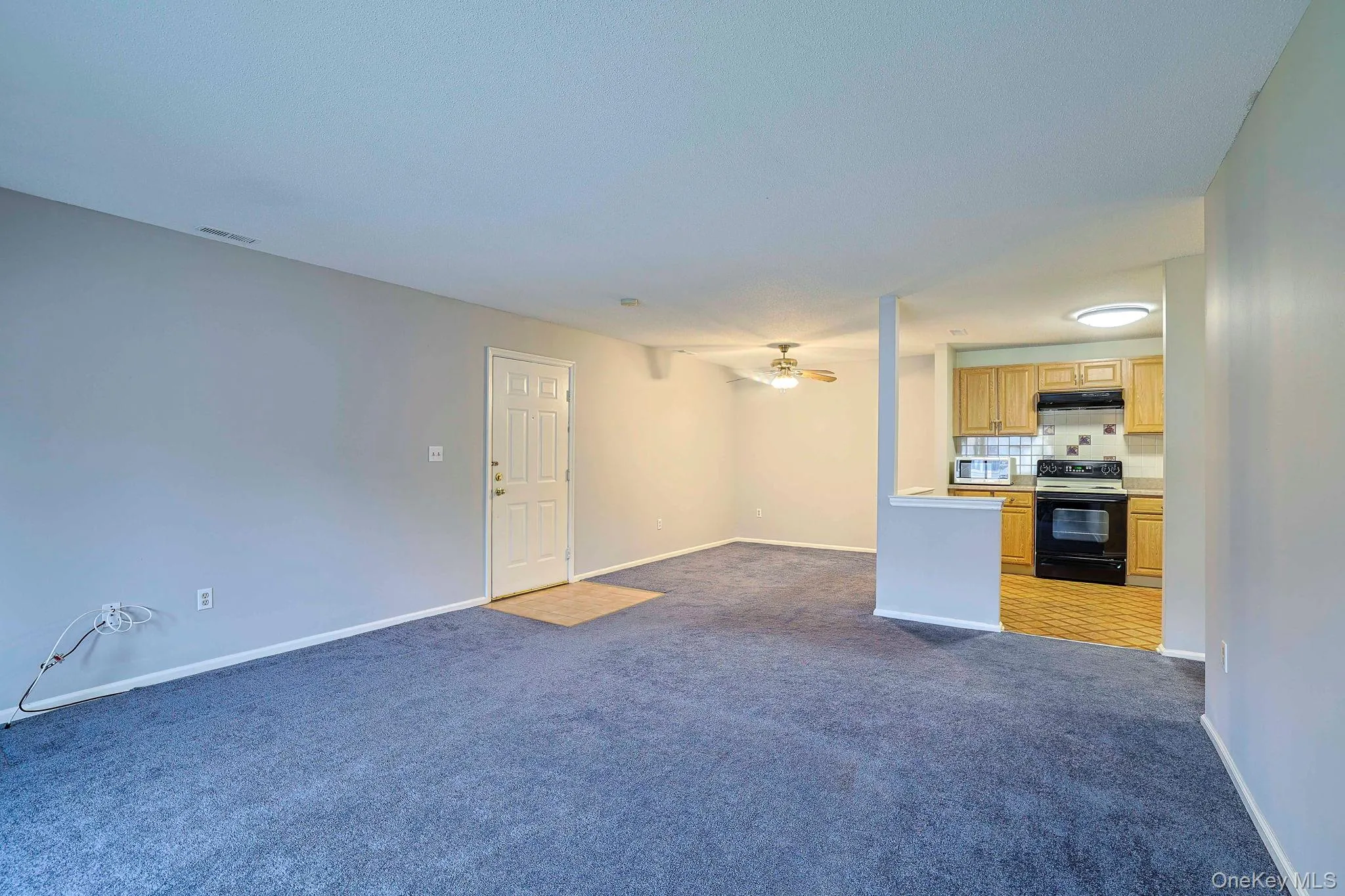 Unfurnished living room featuring dark carpet and ceiling fan Unfurnished living room featuring dark carpet and ceiling fan
