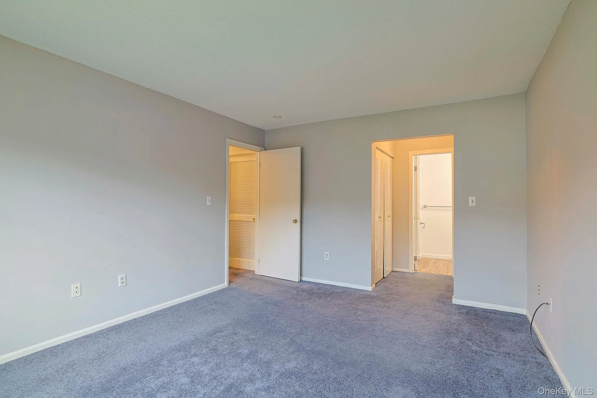 Unfurnished bedroom with carpet flooring and baseboards Unfurnished bedroom with carpet flooring and baseboards