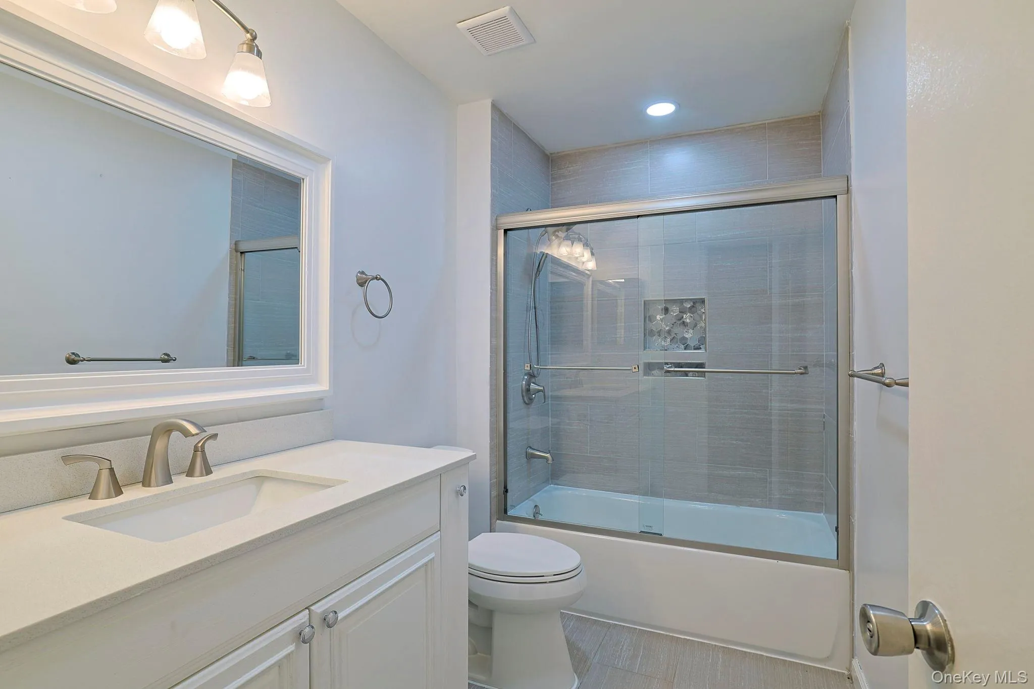 Bathroom featuring enclosed tub / shower combo, vanity, and recessed lighting Bathroom featuring enclosed tub / shower combo, vanity, and recessed lighting