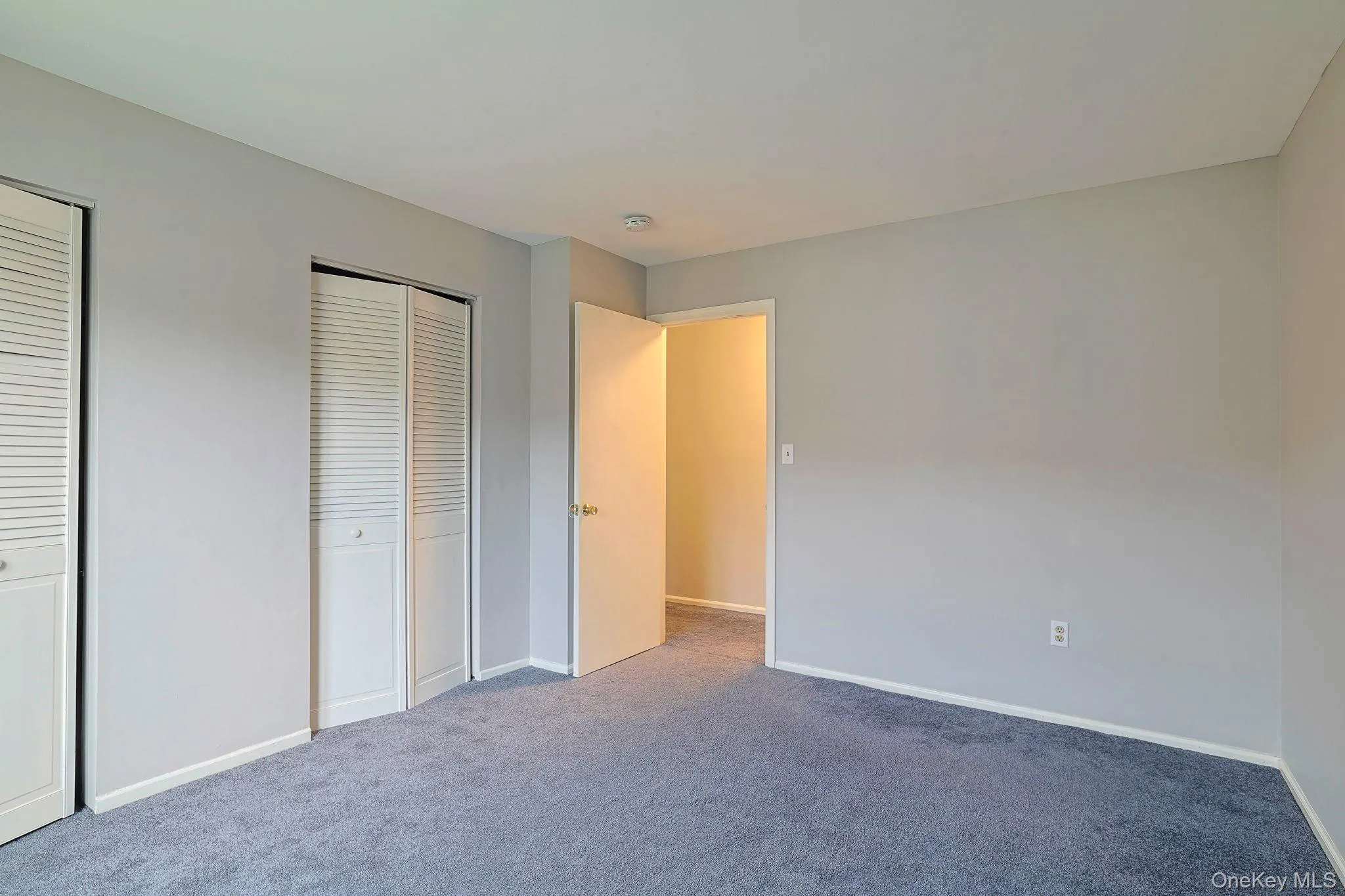 Unfurnished bedroom featuring multiple closets and carpet floors Unfurnished bedroom featuring multiple closets and carpet floors