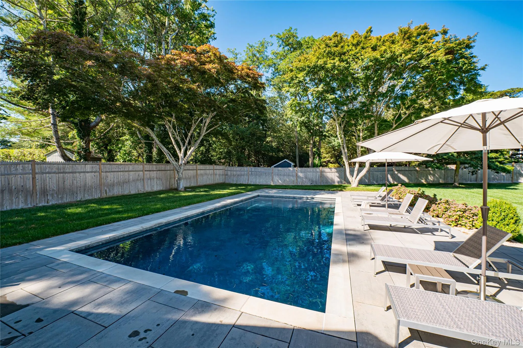 View of swimming pool with a patio and a fenced backyard