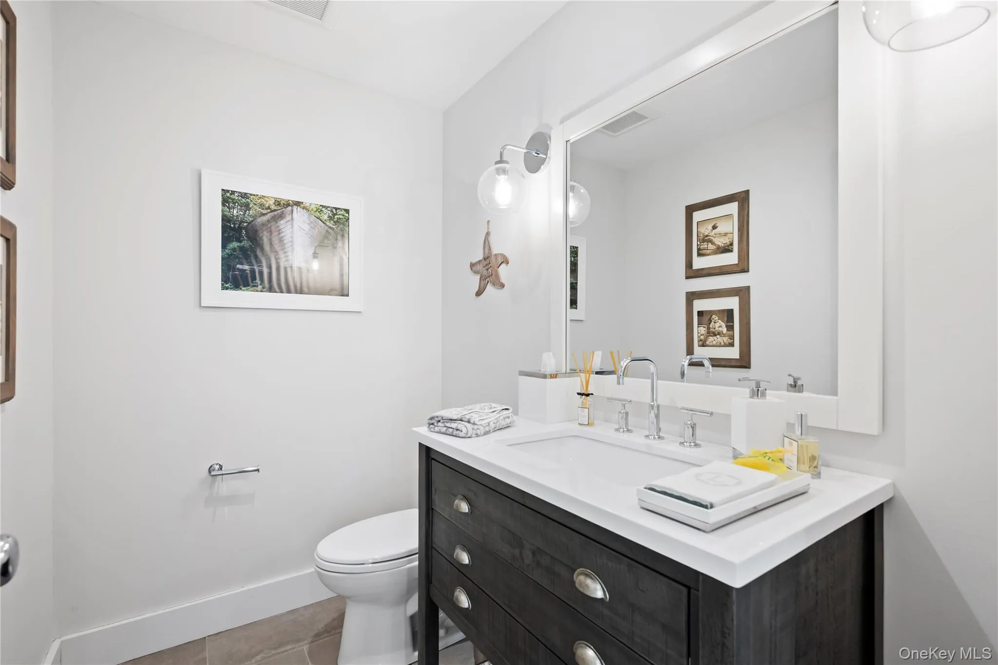 Half bathroom with vanity and light tile patterned floors