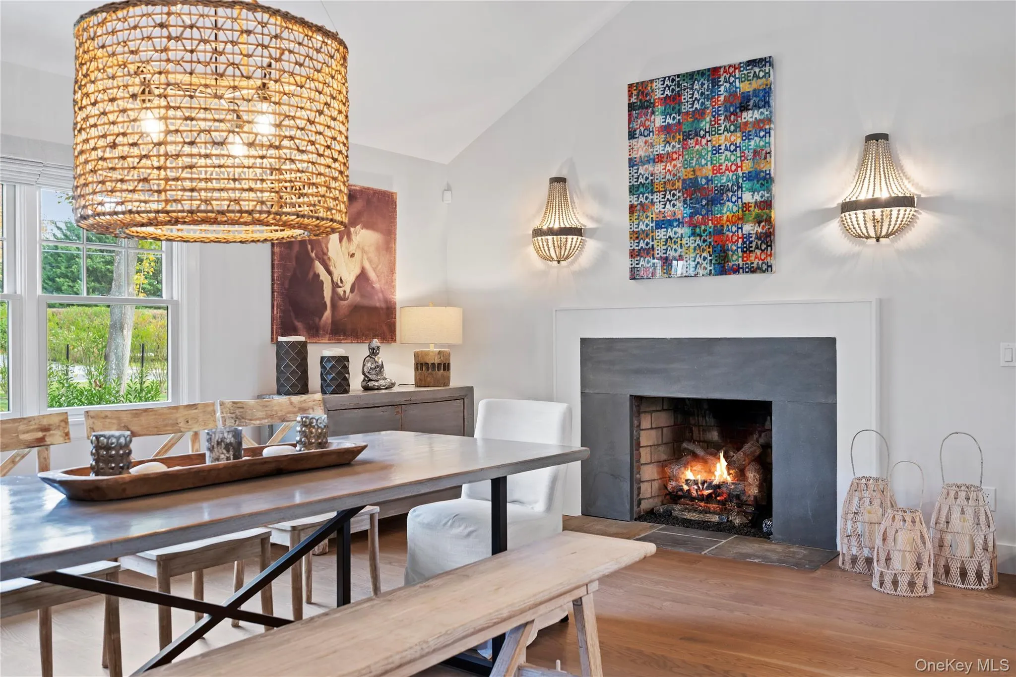 Dining area featuring wood finished floors and a warm lit fireplace
