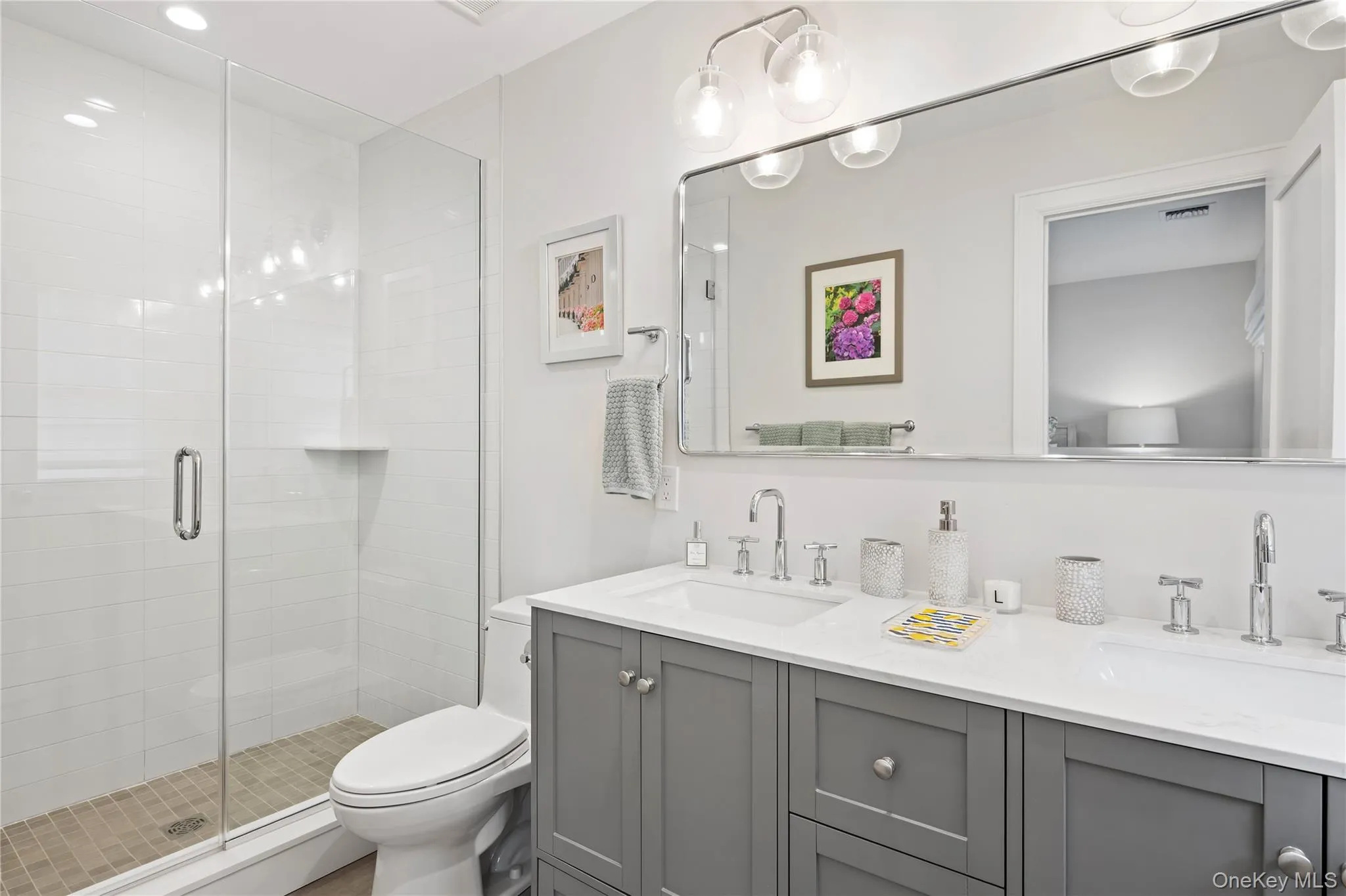 Full bathroom with double vanity and a stall shower