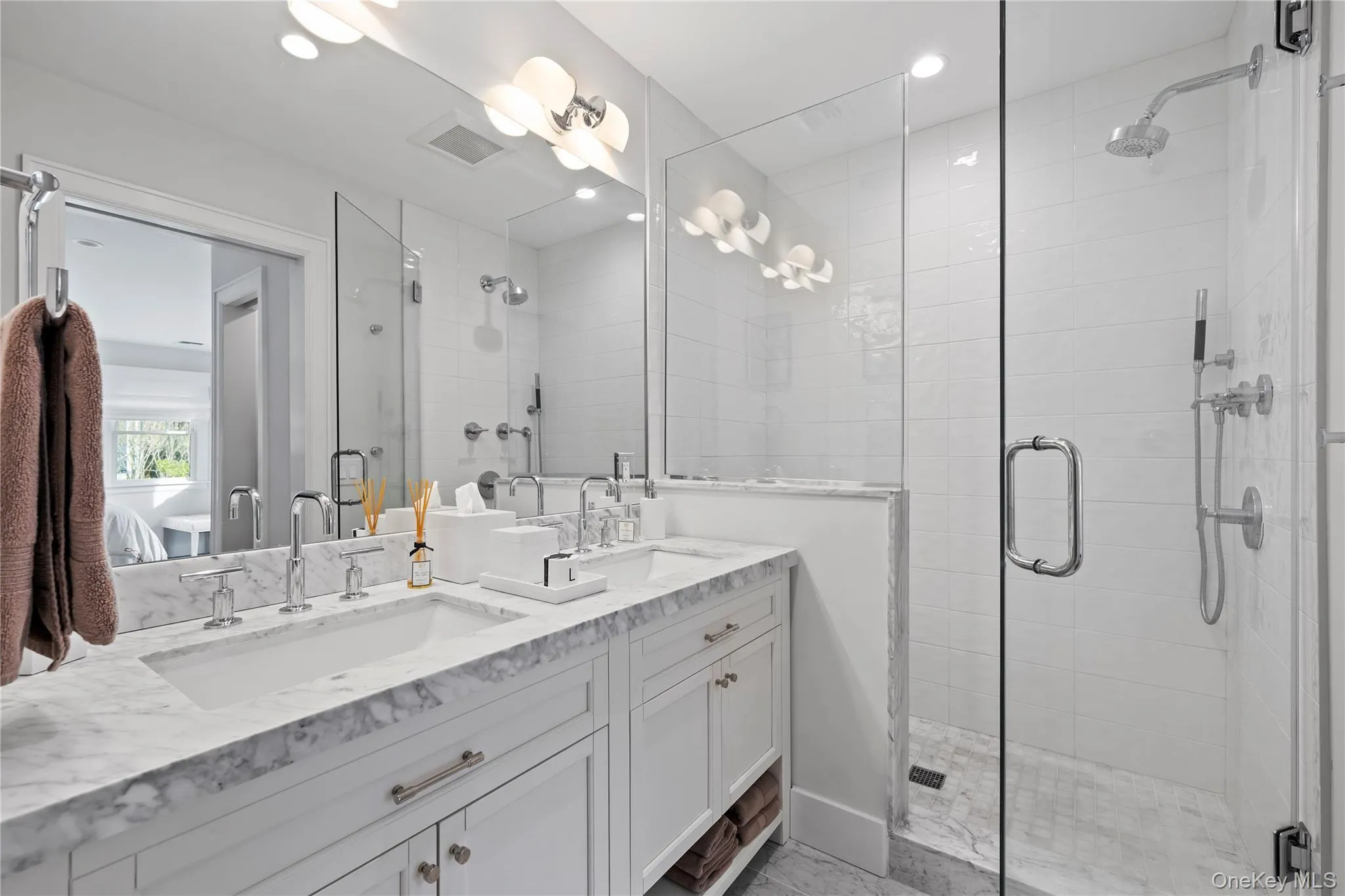 Full bath with double vanity, a shower stall, and ensuite bathroom