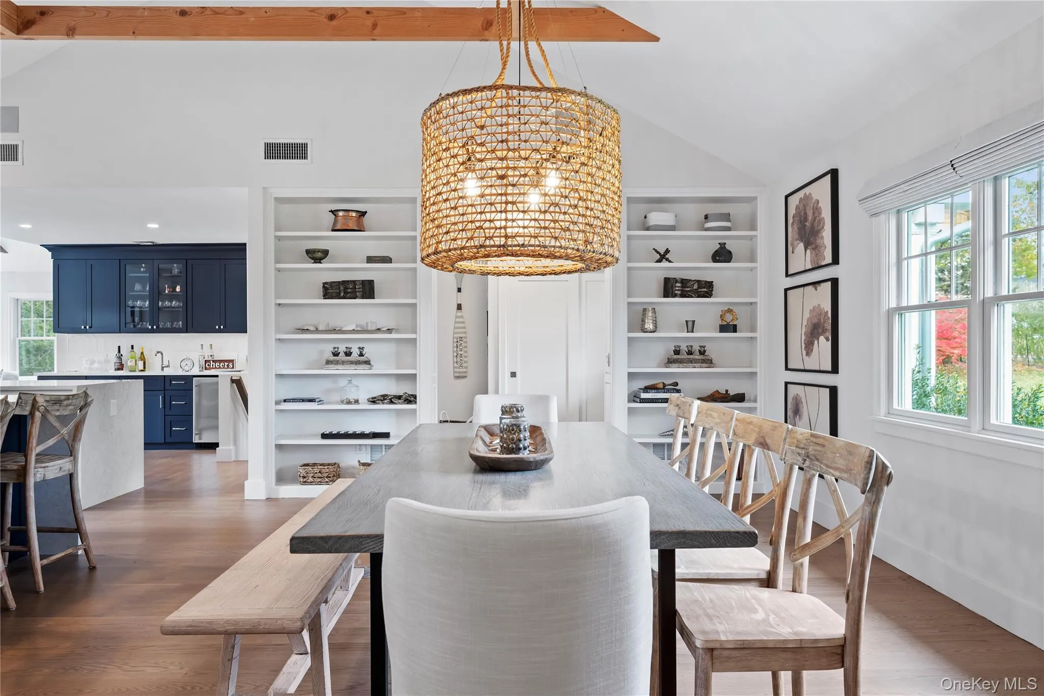 Dining room featuring a chandelier, dark wood-style floors, high vaulted ceiling, and built in shelves