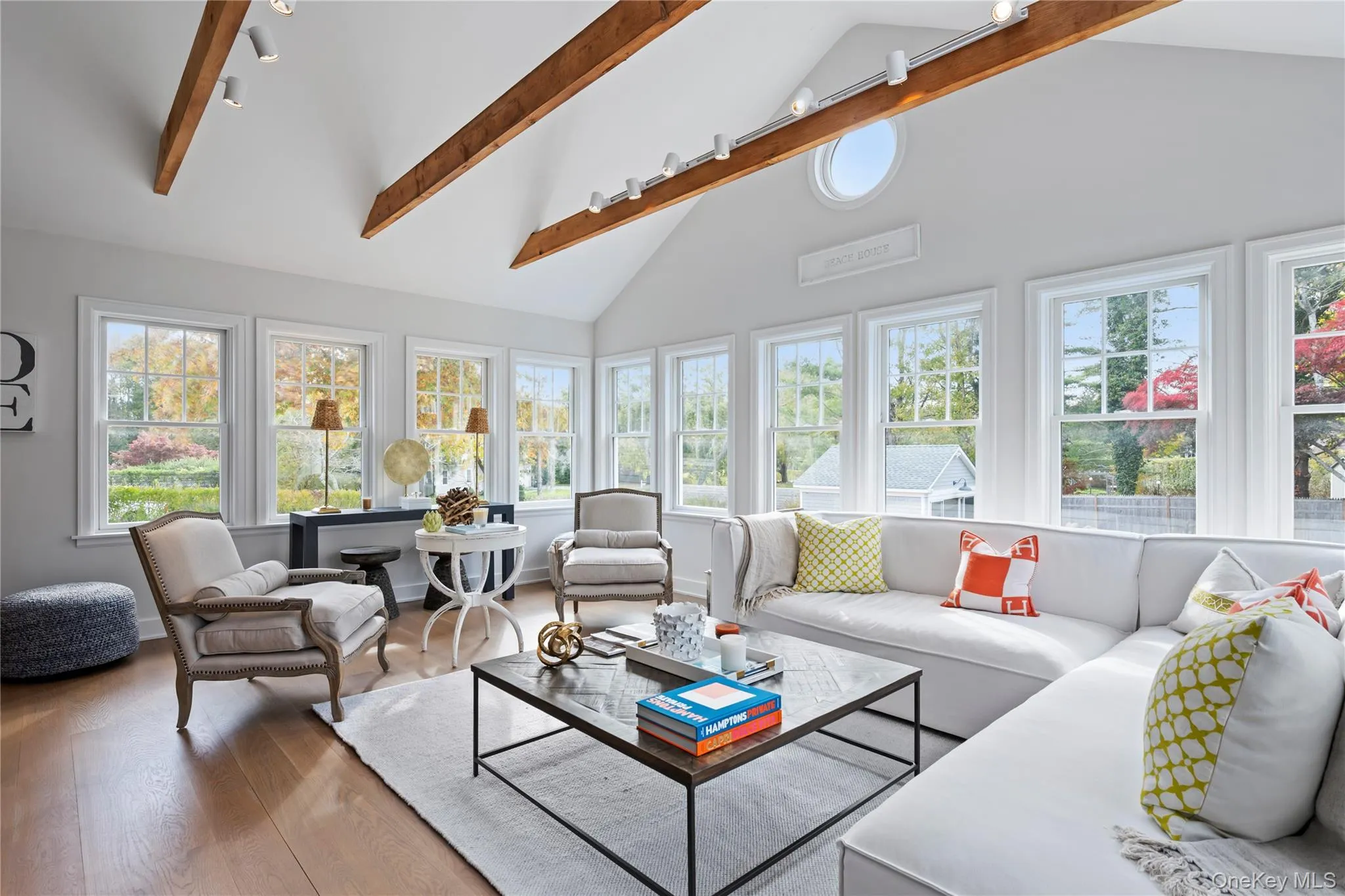Sunroom with beamed ceiling, high vaulted ceiling, and wood finished floors