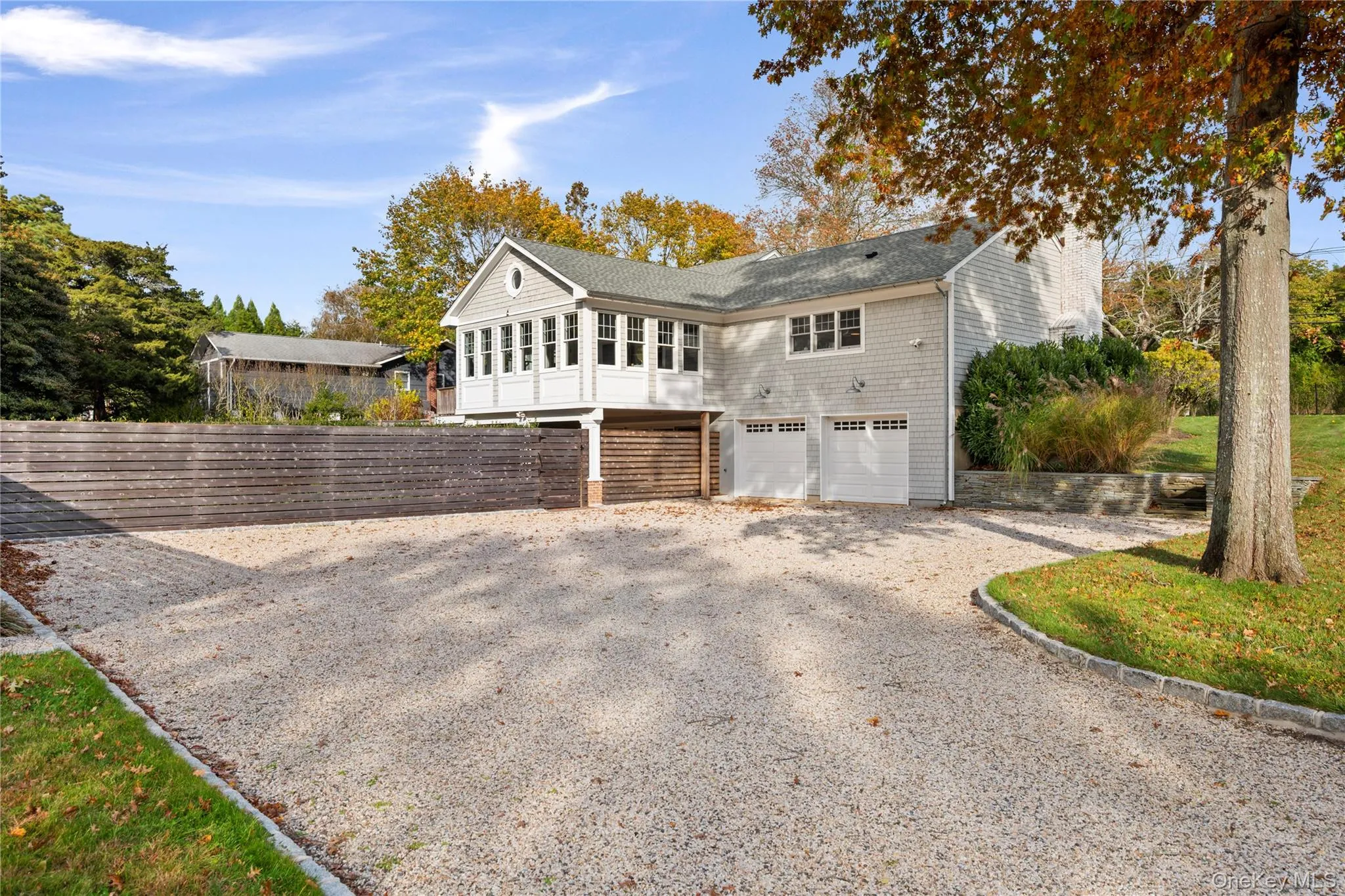 View of side of home featuring driveway, an attached garage, and roof with shingles