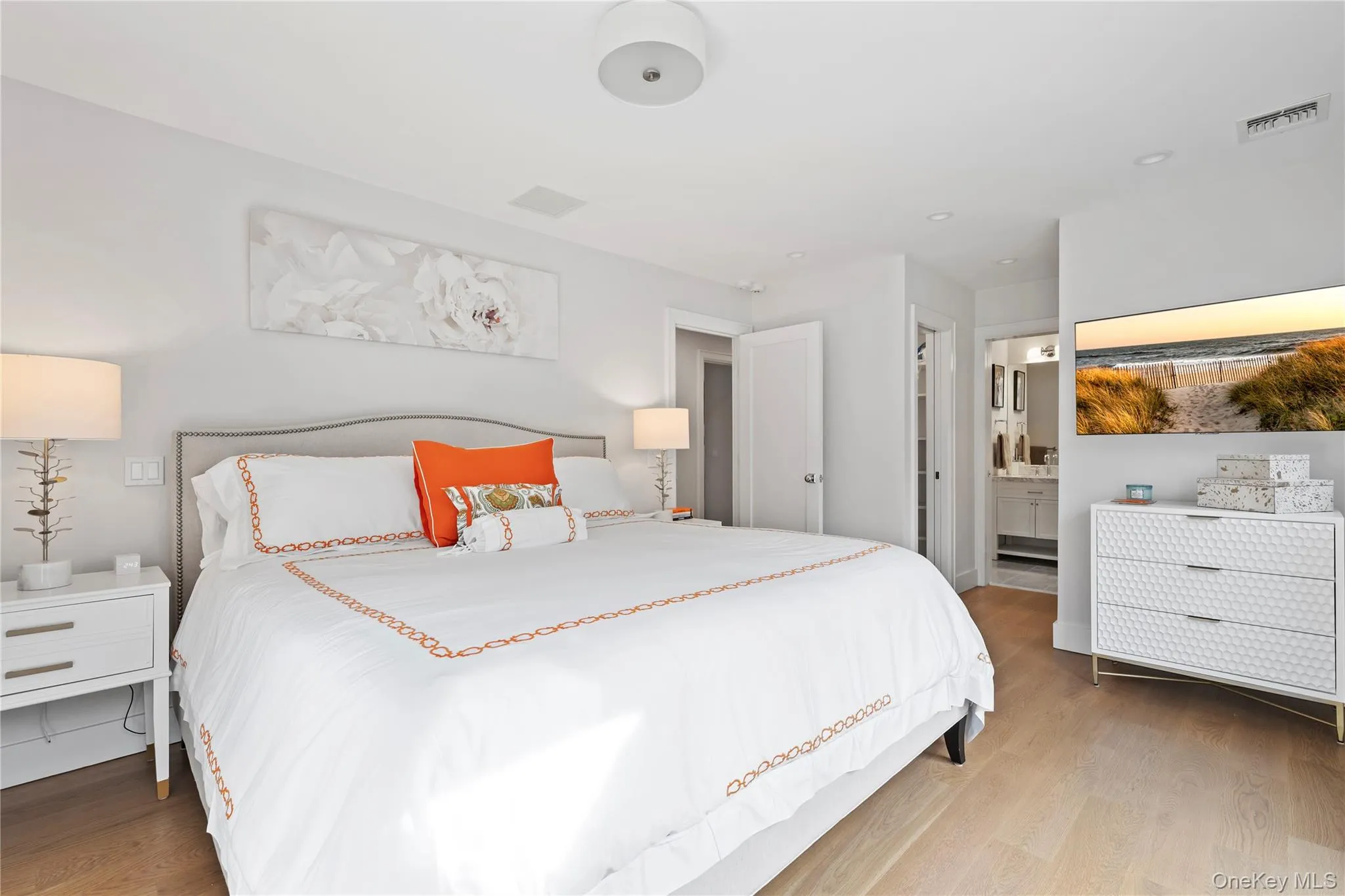 Bedroom with wood finished floors and ensuite bath