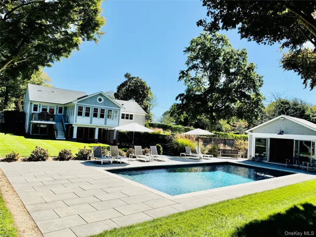 View of swimming pool with a patio area, stairs, an outbuilding, and an exterior structure