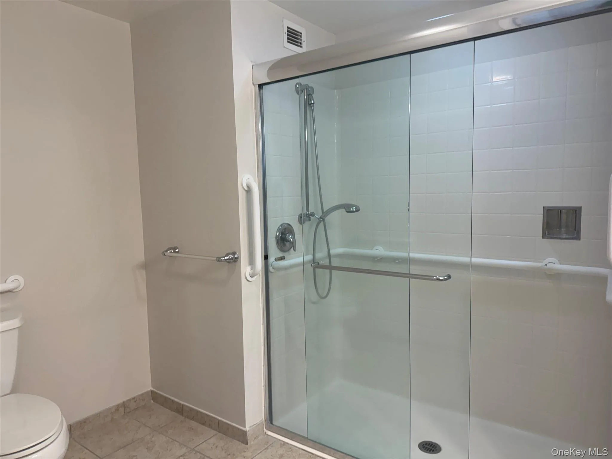 Full bathroom with large walk-in shower and safety features Full bathroom with large walk-in shower and safety features