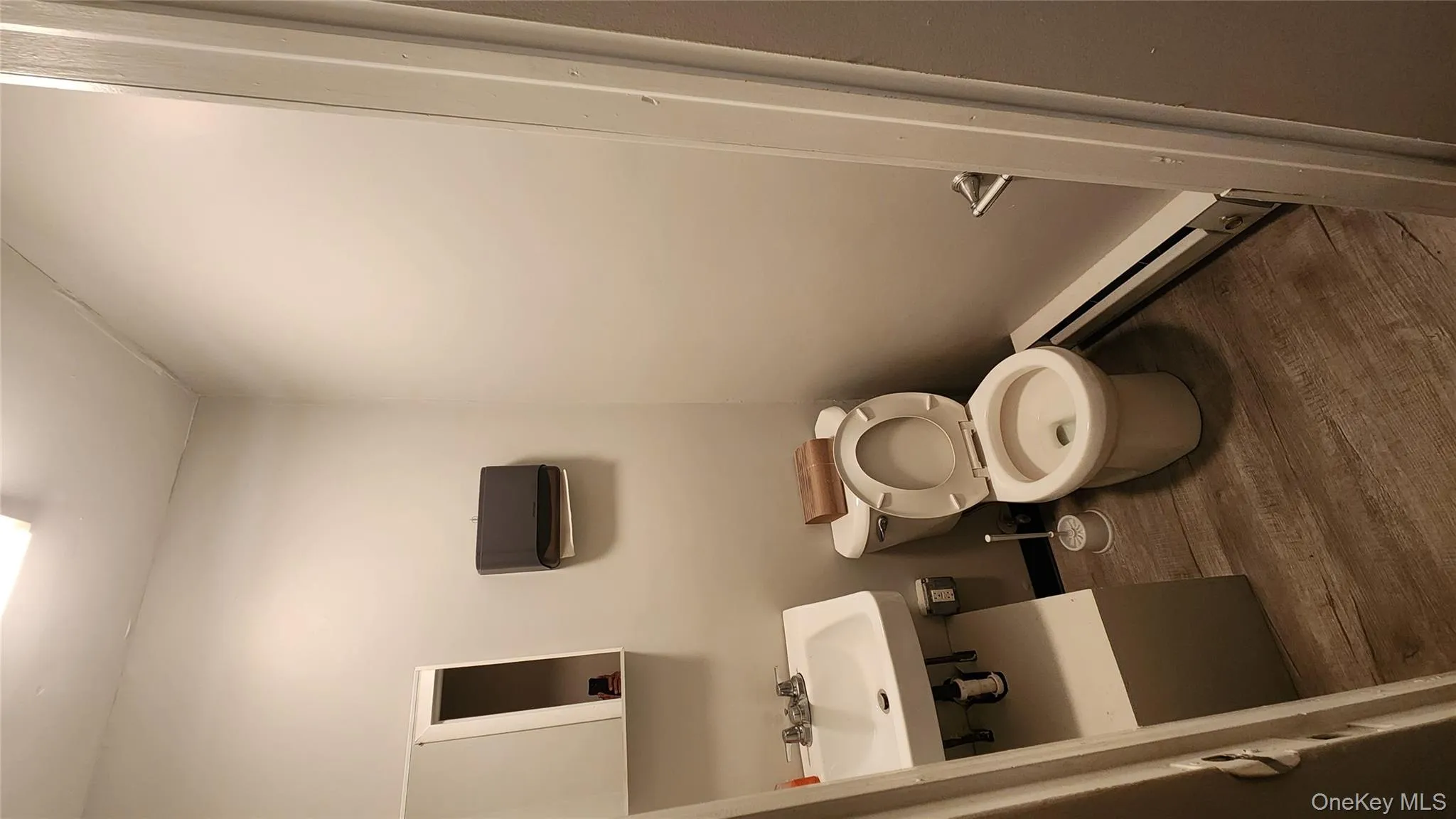 Bathroom with dark wood-style flooring and a baseboard heating unit Bathroom with dark wood-style flooring and a baseboard heating unit