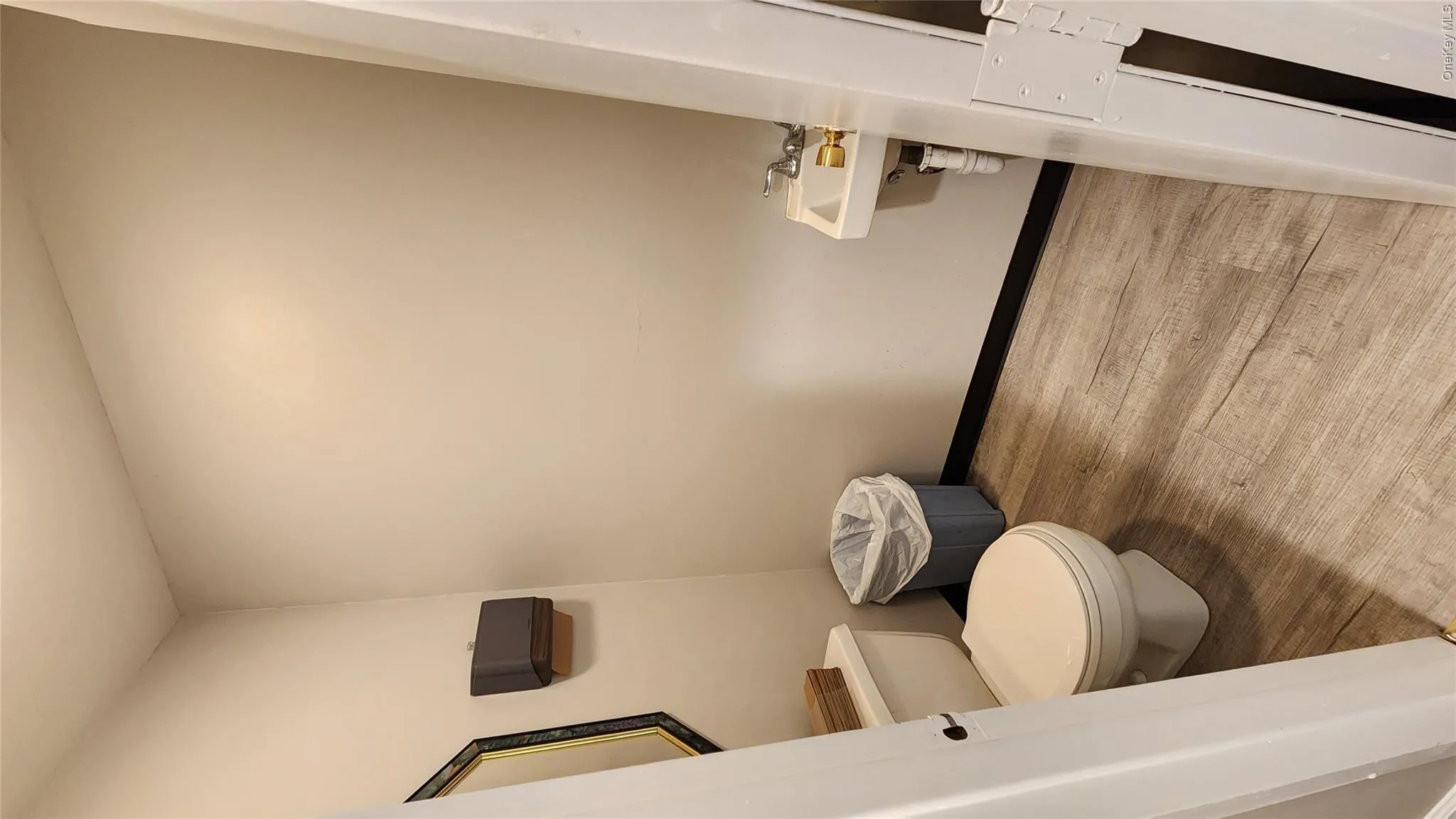 Half bath with light wood-style flooring and toilet Half bath with light wood-style flooring and toilet