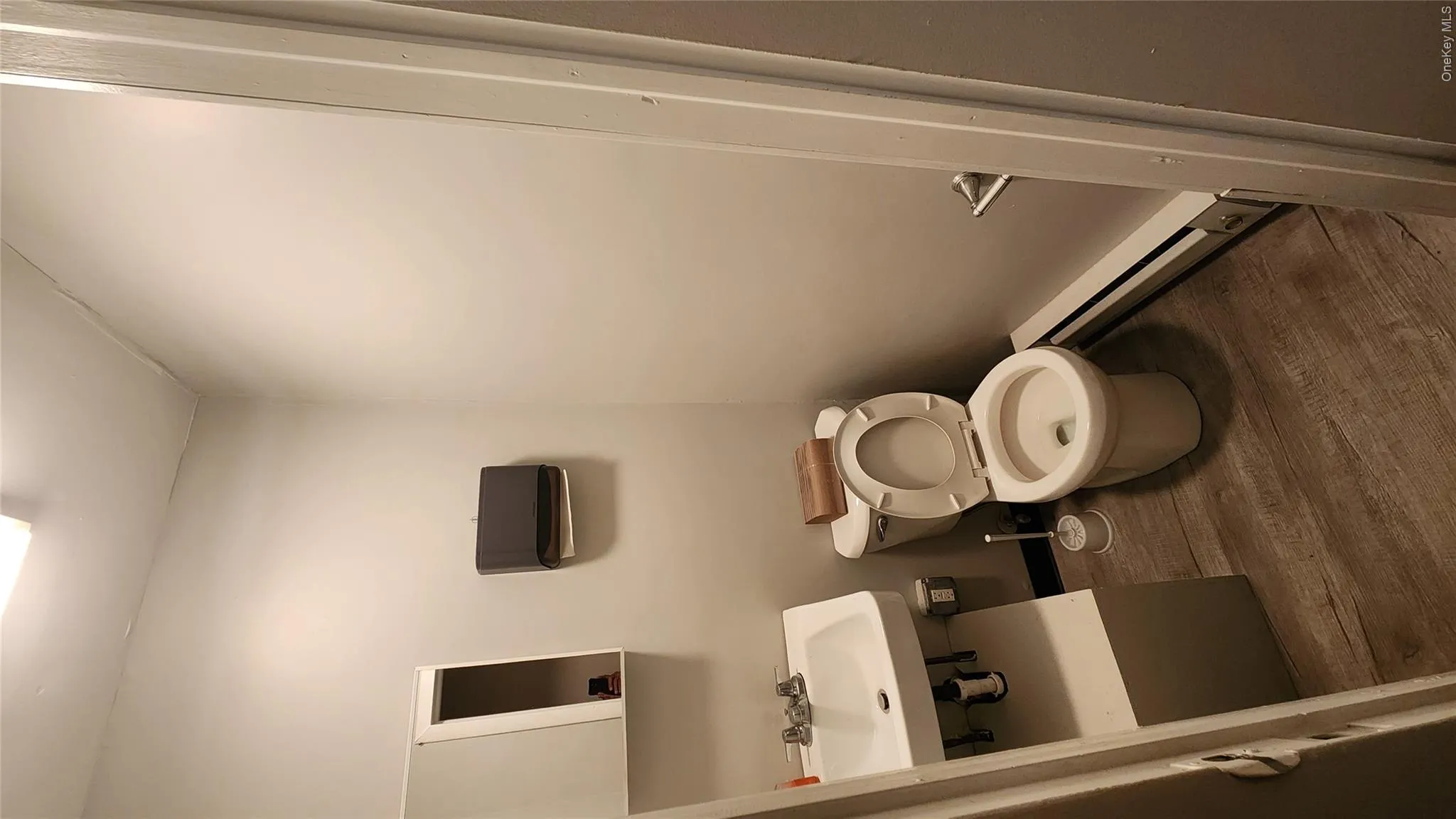 Bathroom with dark wood-style flooring and a baseboard heating unit Bathroom with dark wood-style flooring and a baseboard heating unit