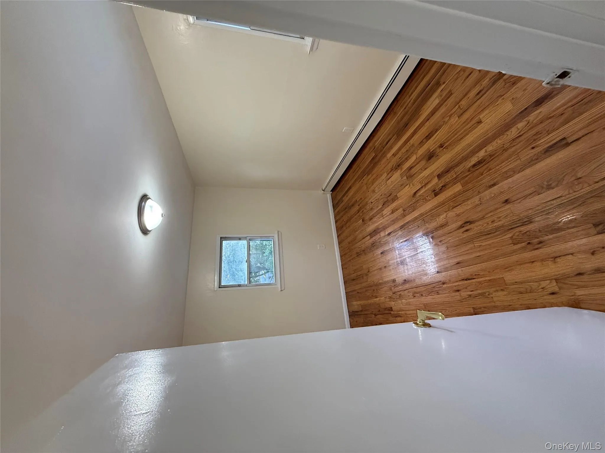 Empty room featuring a baseboard heating unit and hardwood / wood-style floors Empty room featuring a baseboard heating unit and hardwood / wood-style floors