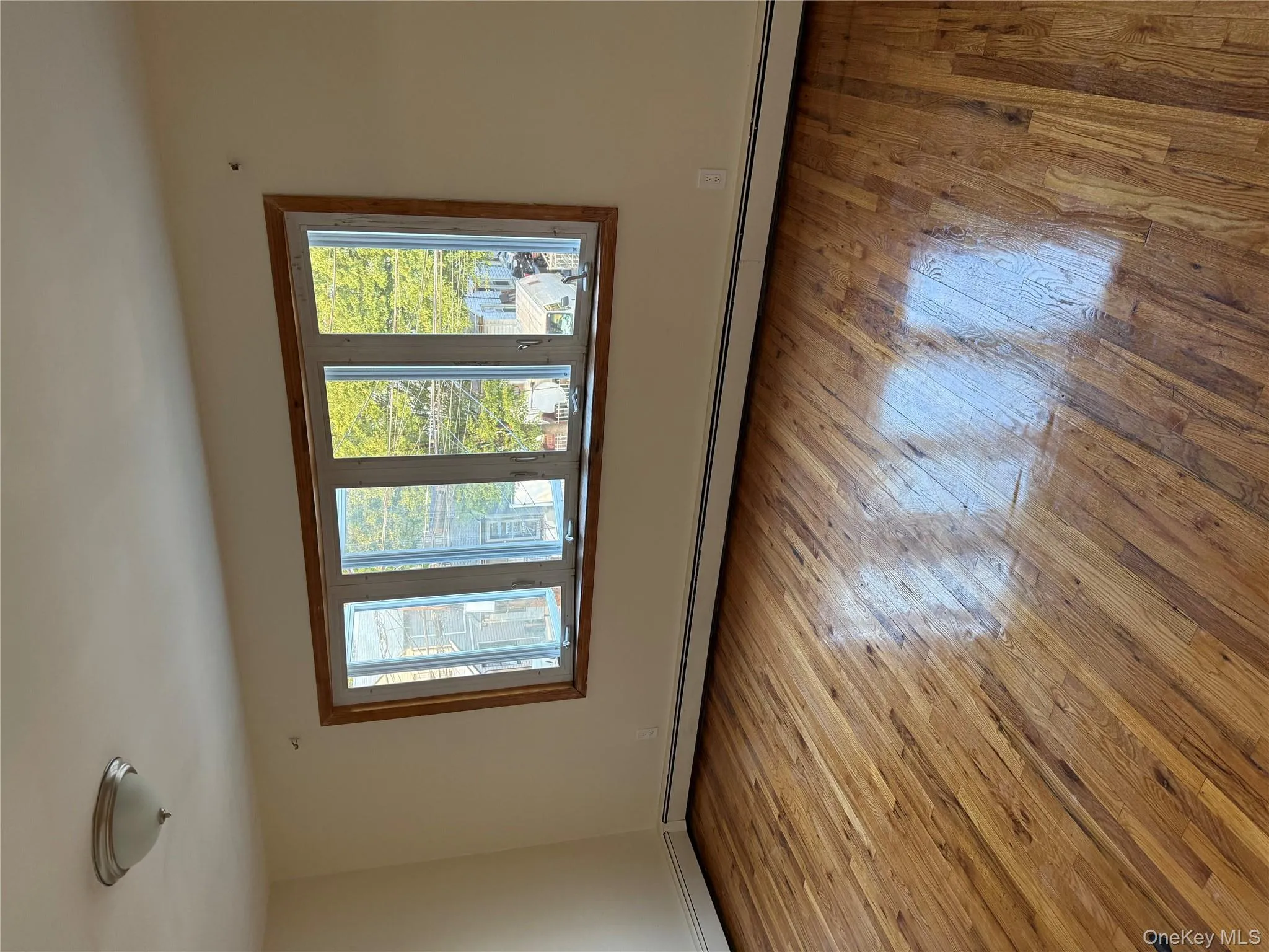 Empty room featuring light wood finished floors and a baseboard heating unit Empty room featuring light wood finished floors and a baseboard heating unit