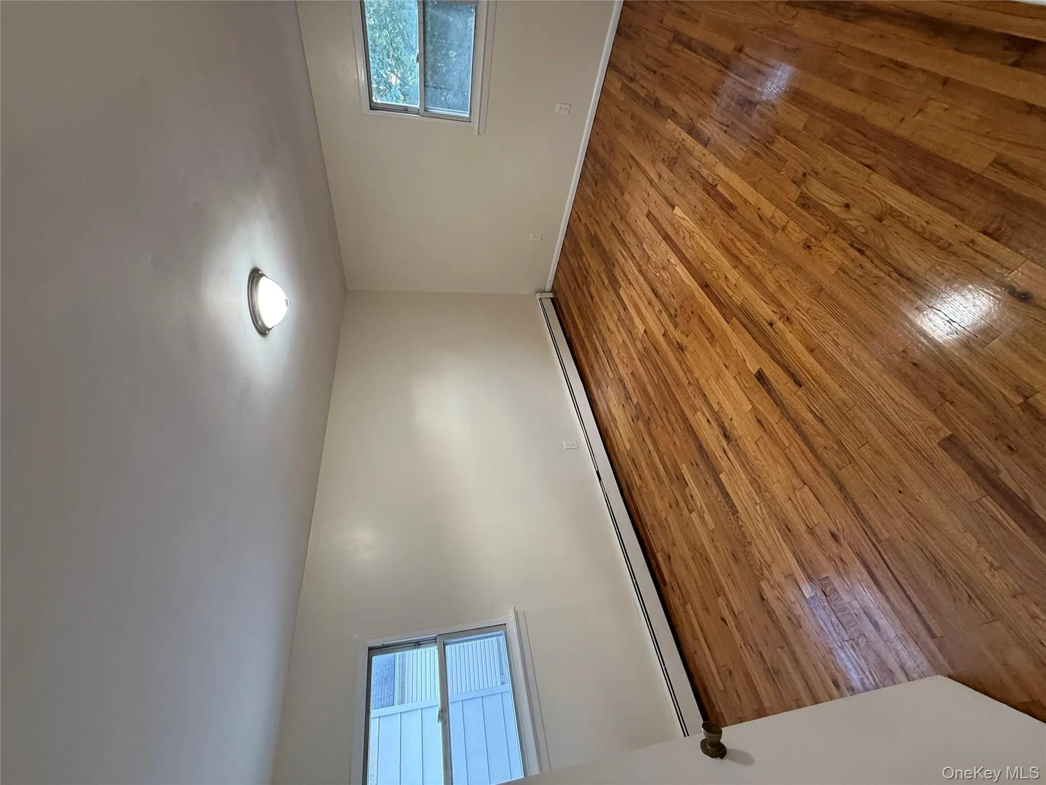 Unfurnished room with light wood-type flooring and baseboard heating Unfurnished room with light wood-type flooring and baseboard heating